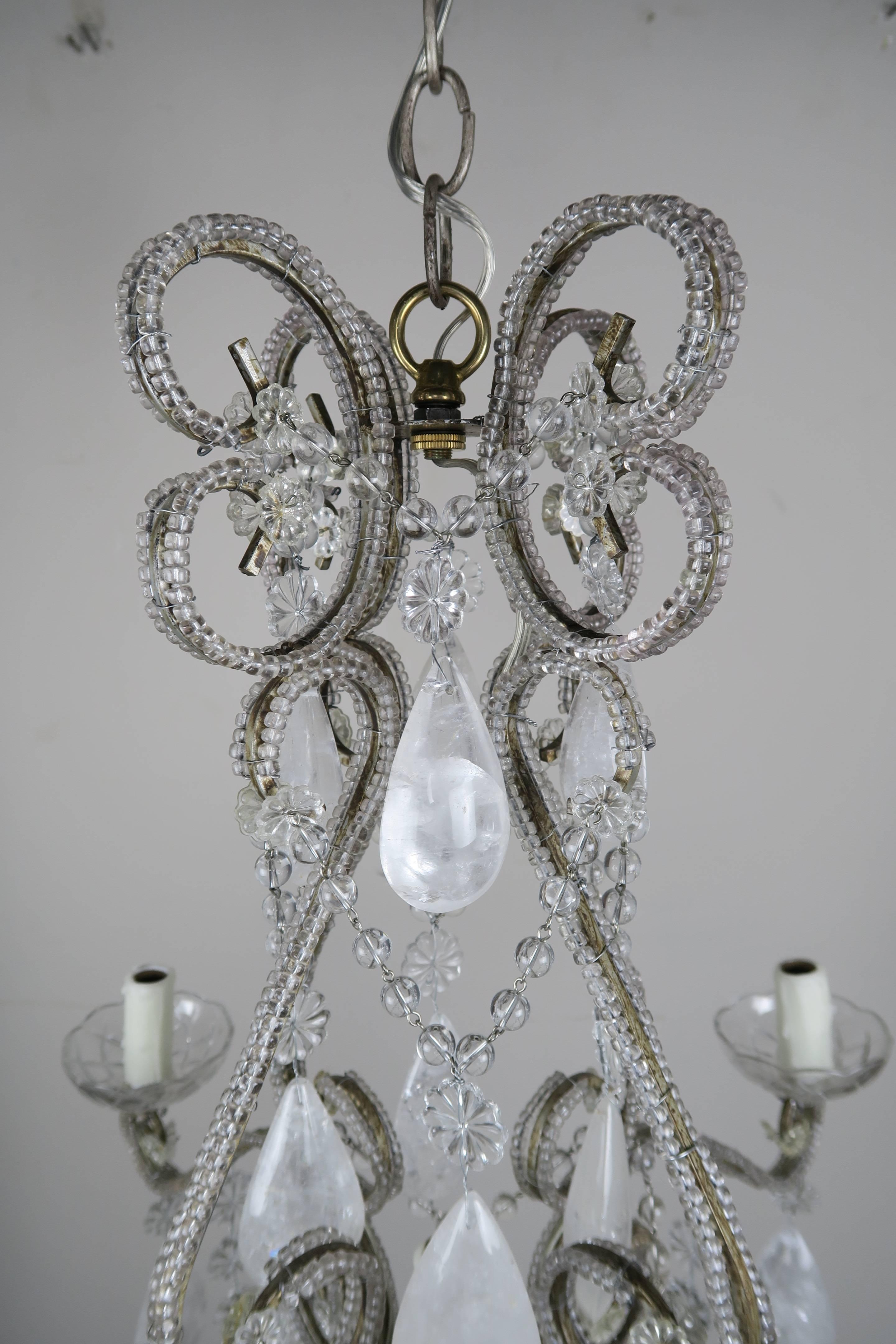 Five-light crystal beaded chandelier adorned with almond shaped rock crystals and a large rock crystal ball at the bottom. The fixture has been newly rewired with drip wax candle covers. Chain and canopy included.