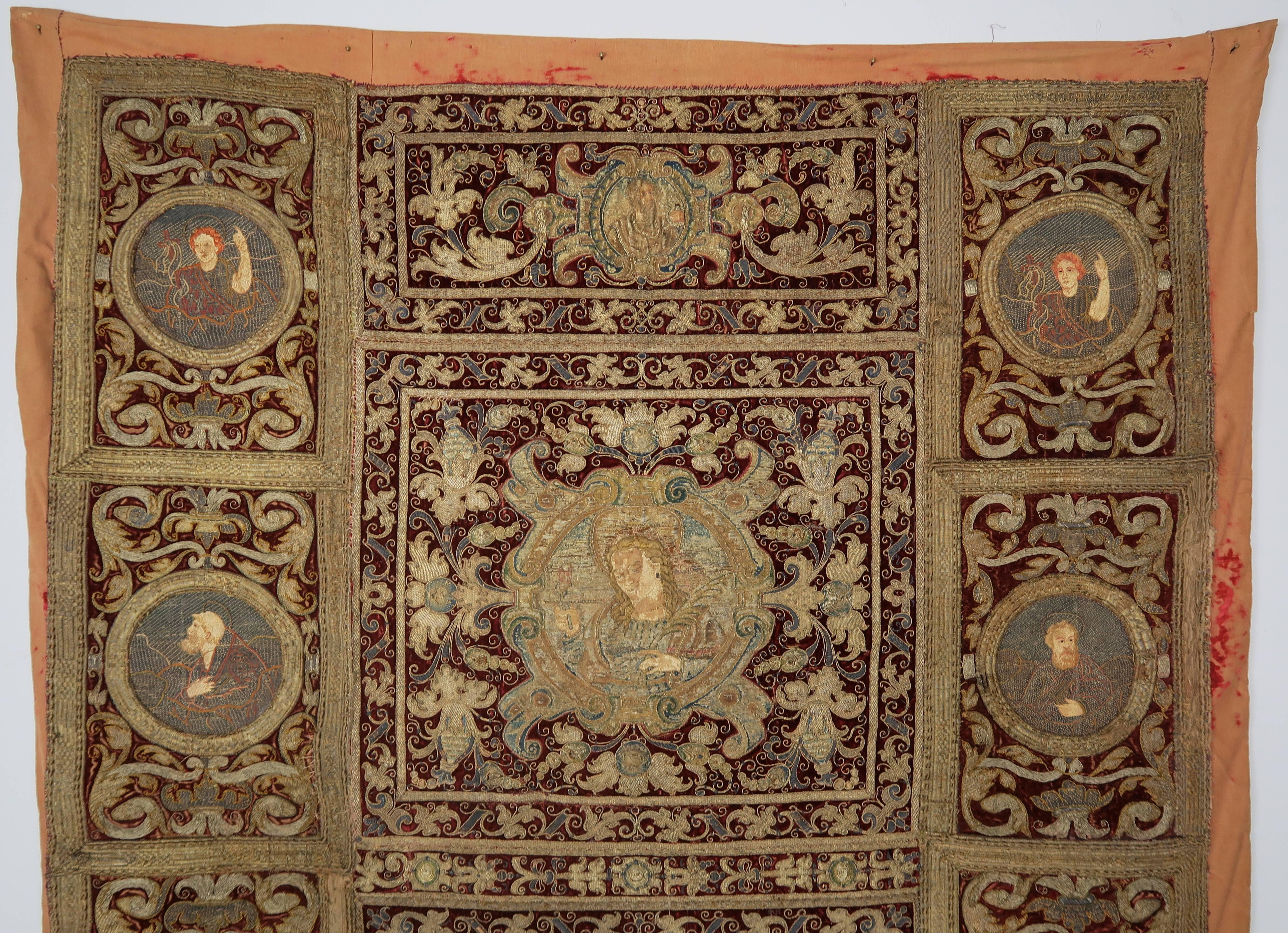 Detailed, 18th Century Italian metallic embroidered Tapestry with Velvet silk border with metallic appliques throughout and metallic fringe trim at bottom edge. Dark crimson red with gold circular frames of various saints are finely done in