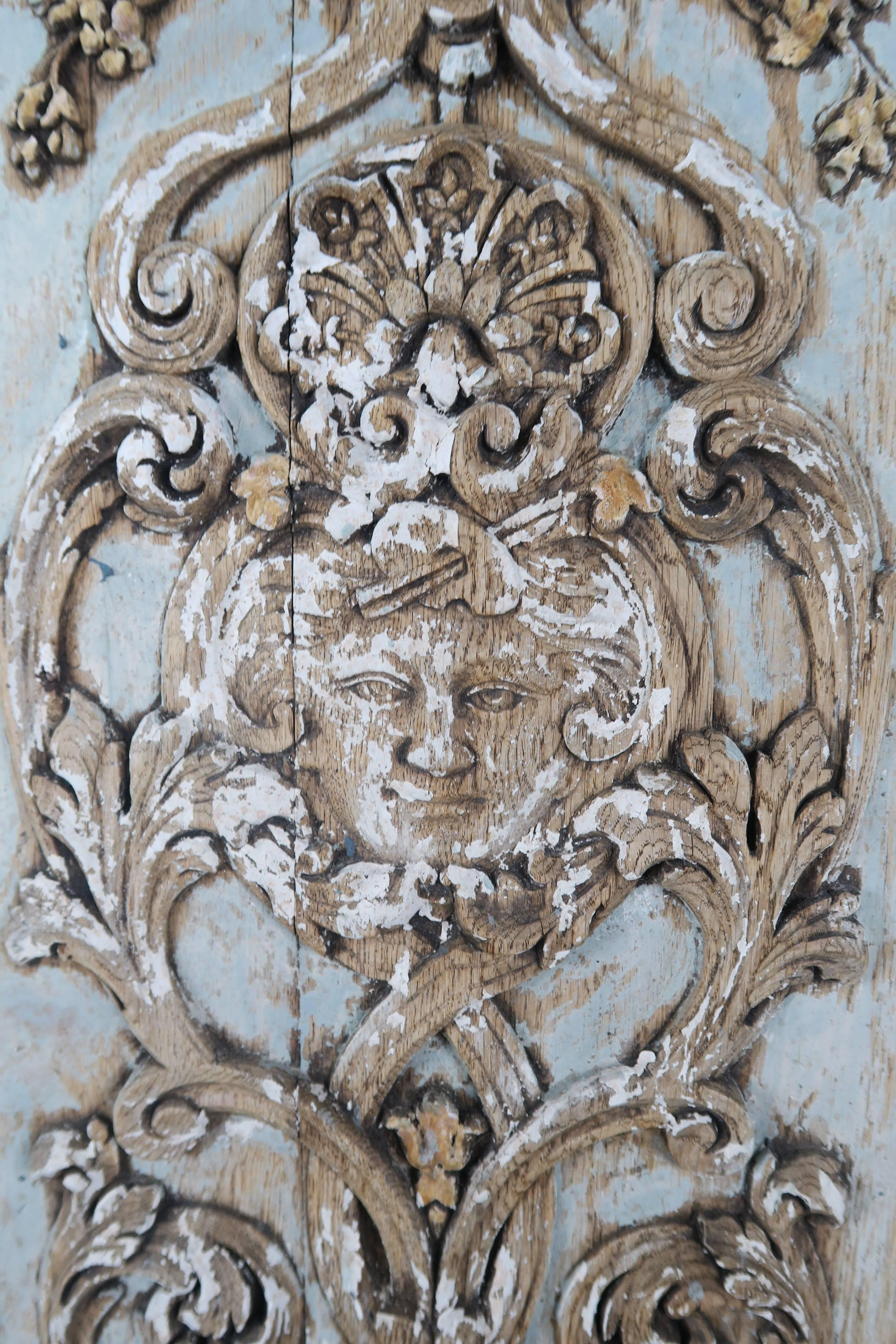 19th century Italian painted carved wood panel depicting a face with swags, flowers and swirling acanthus leaves throughout. Beautiful distressed painted finish.