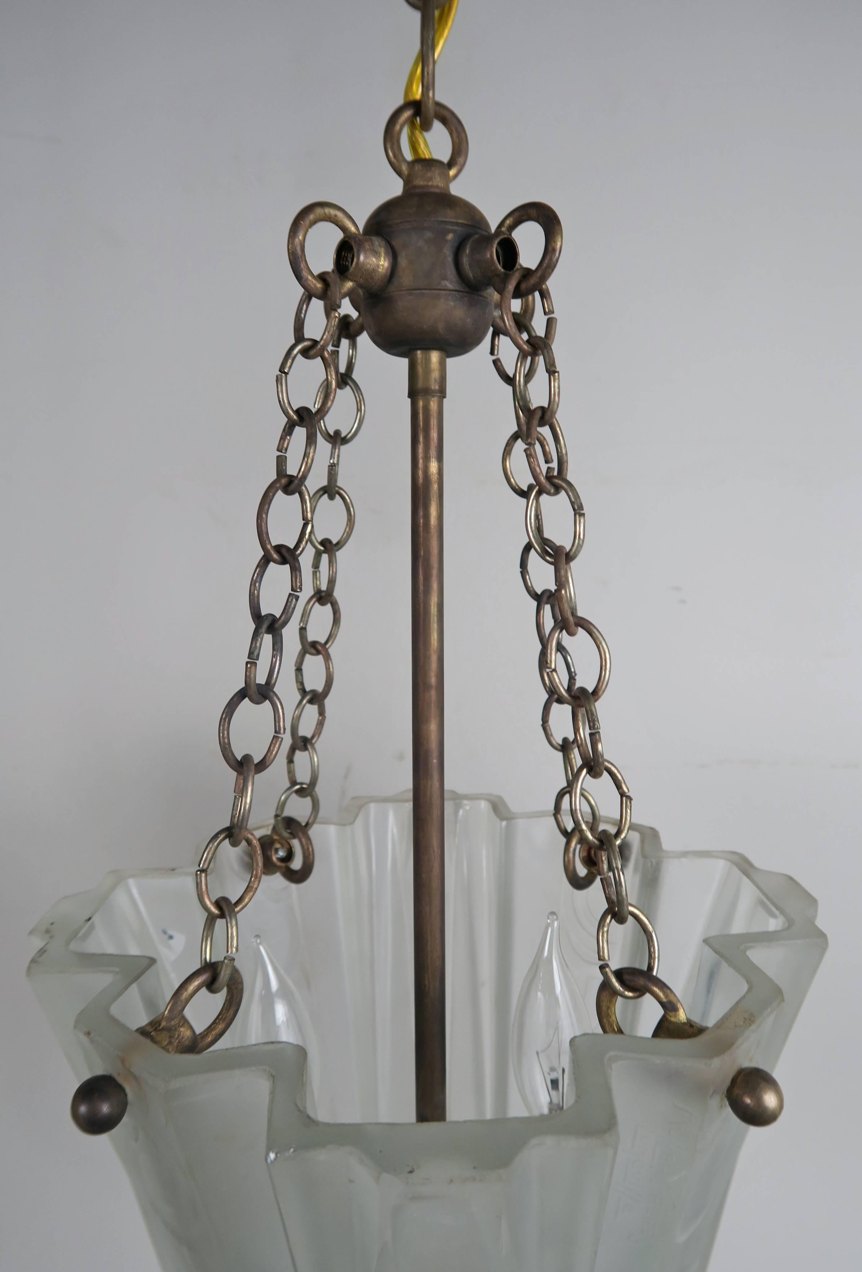 Offered by Melissa Levinson Antiques

Pair of Art Nouveau hanging light fixtures that hang from four chains connected to a brass ball. Two lights sit inside that can accommodate up to 50 watts in each fixture; thick etched and molded frosted glass.