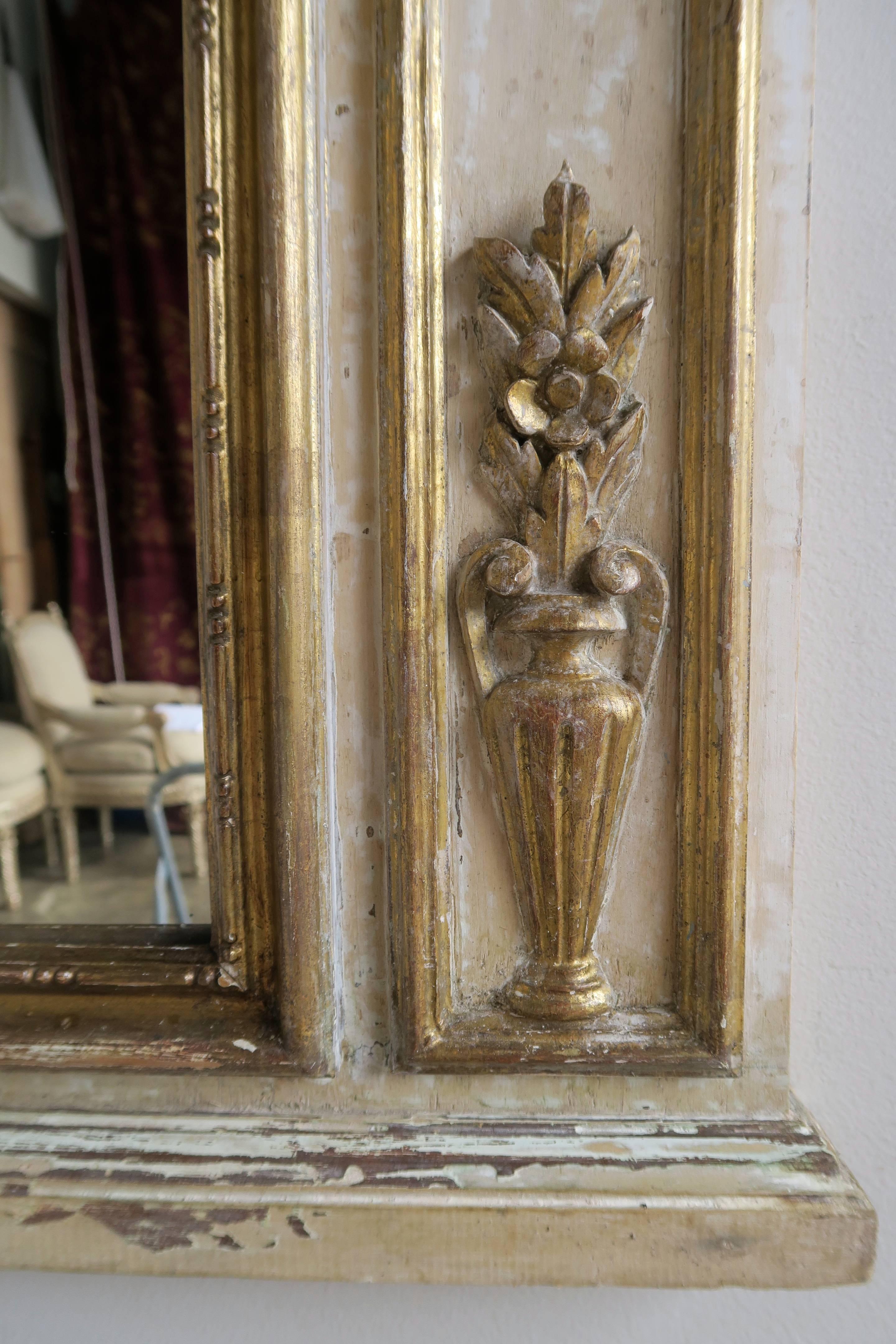 French Louis XV style painted and parcel-gilt mirror depicting musical instruments combined with urns and flowers throughout. Weathered painted finish.
