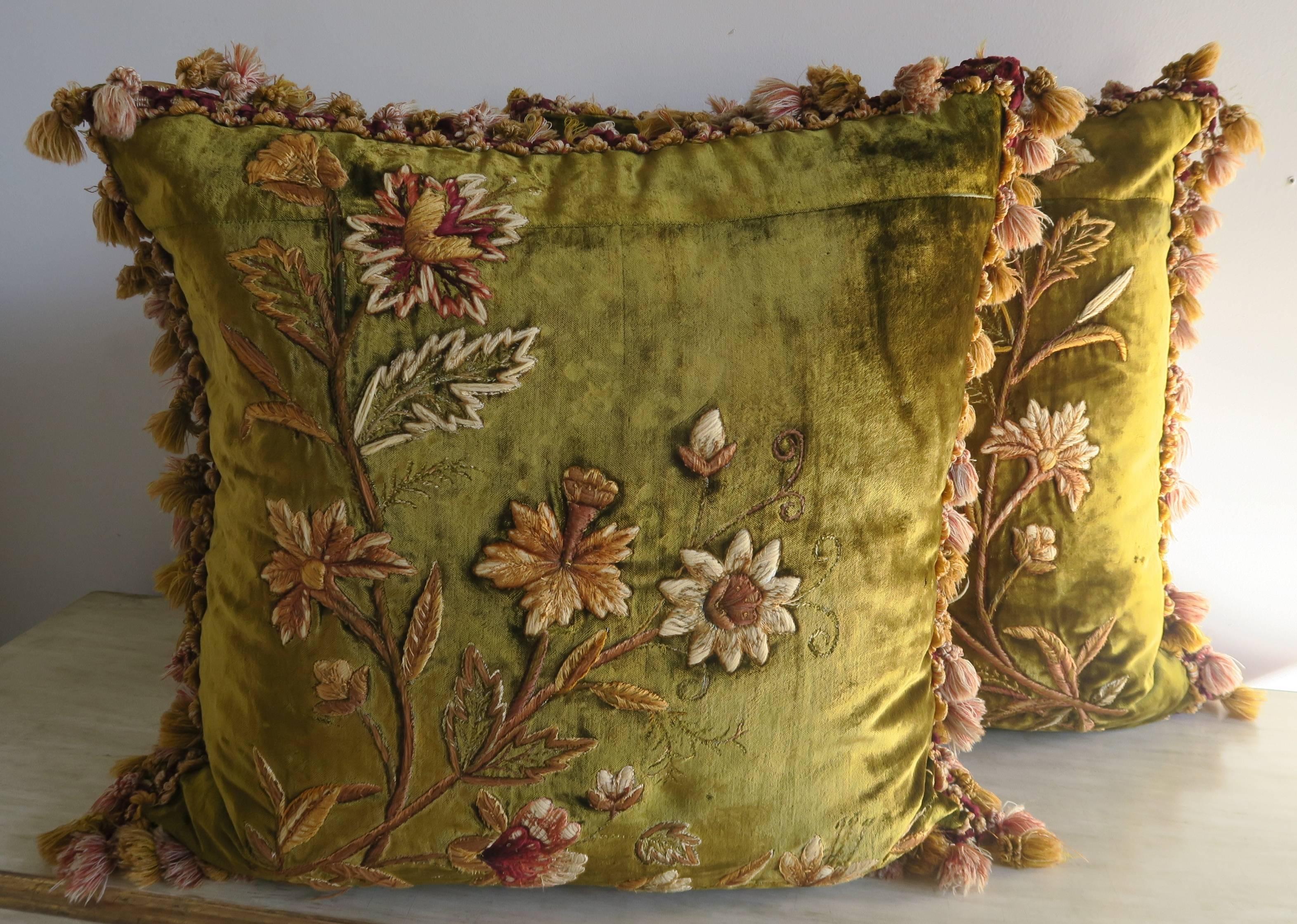 Pair of custom pillows design by Melissa Levinson. This pair of pillows is made from 19th century hand embroidered green silk velvet fronts and gold silk taffeta backs. Antique tassel trim around the sides of both pillows. Down inserts.