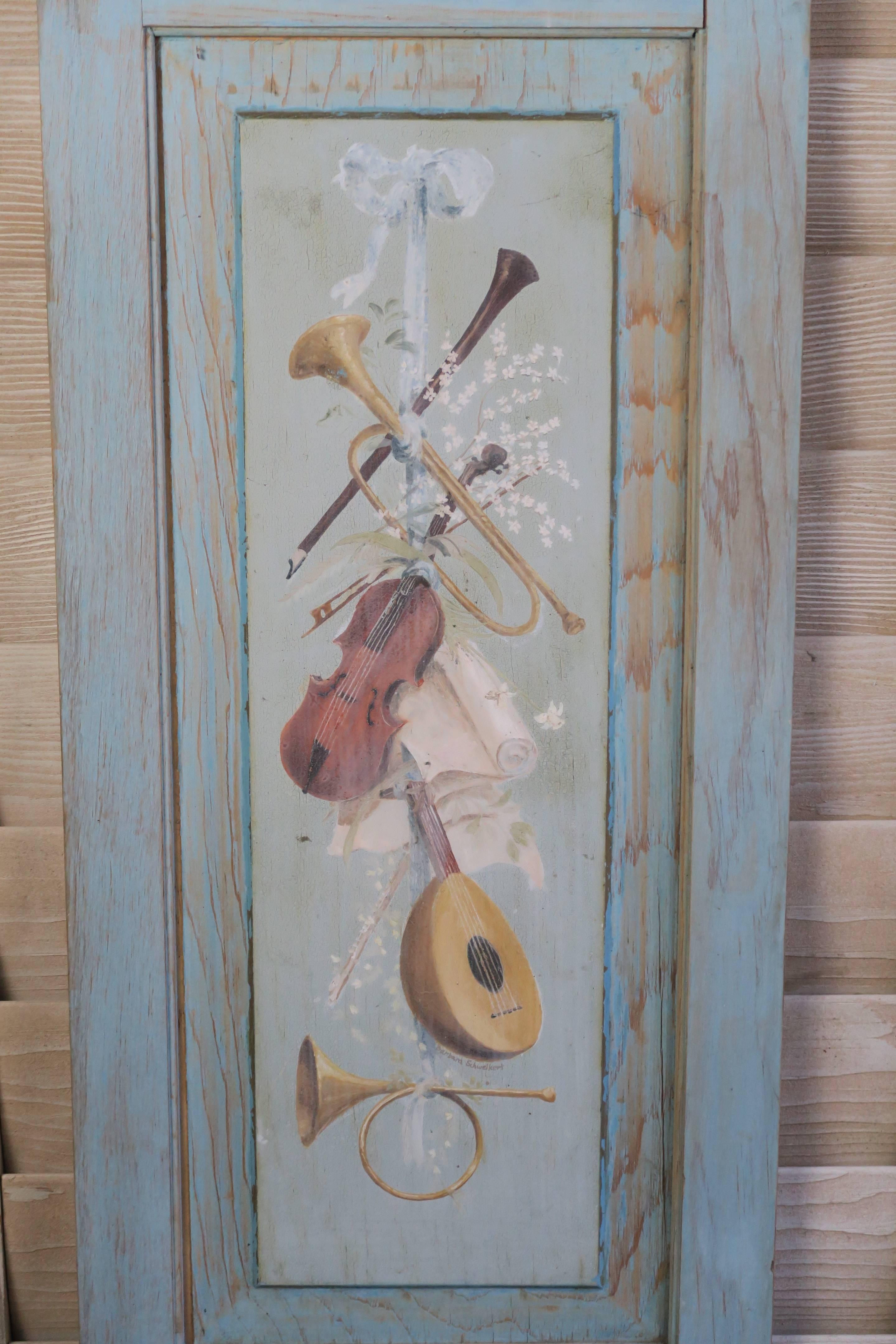French blue painted panels with musical instruments, birds and branches. Worn painted finish in beautiful shades of blue, green and gold.