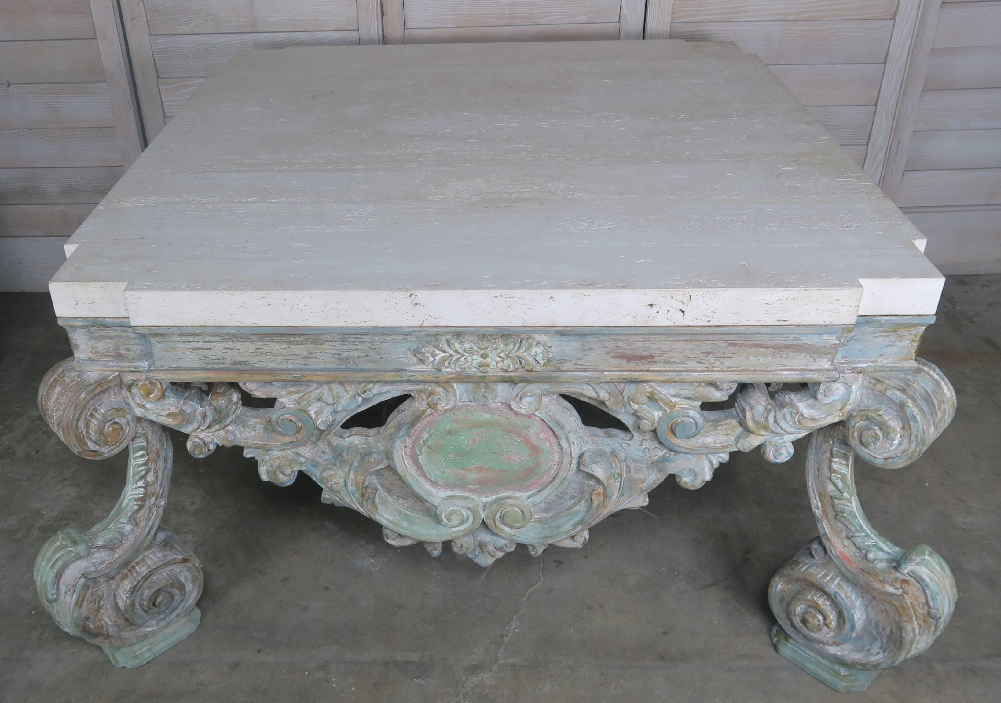 French Louis XV style hand-carved wood coffee table standing on four scrolled legs. All four sides have beautiful intricate carvings depicting swirling acanthus leaves around a center cartouche. Worn paint remains throughout. Measures: 2