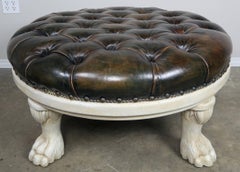 Pouf rond en cuir touffeté avec pieds en patte sculptés