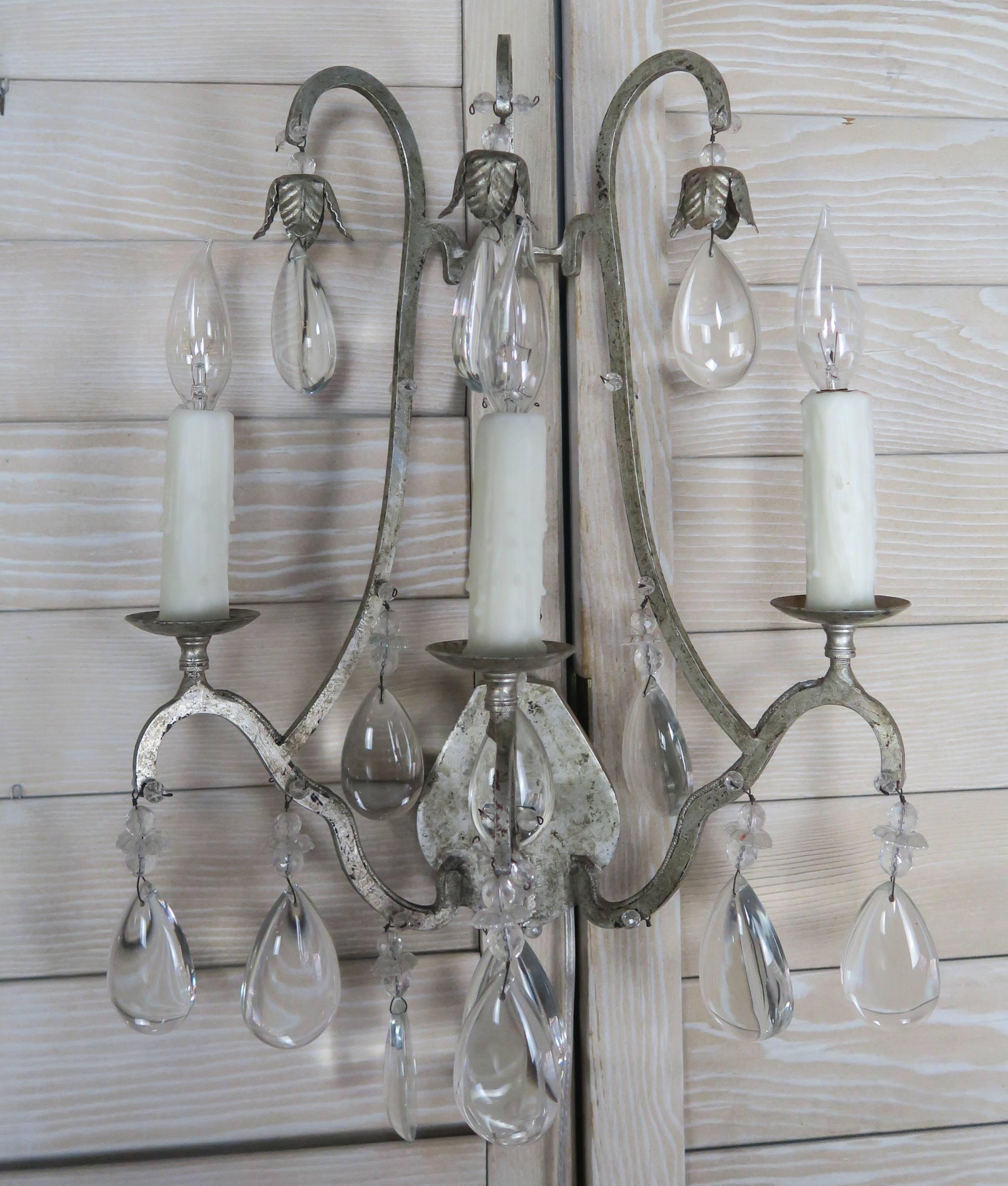 Pair of Italian silvered three-light sconces with smooth almond shaped crystals. The sconces have been newly wired with drip wax candle covers.