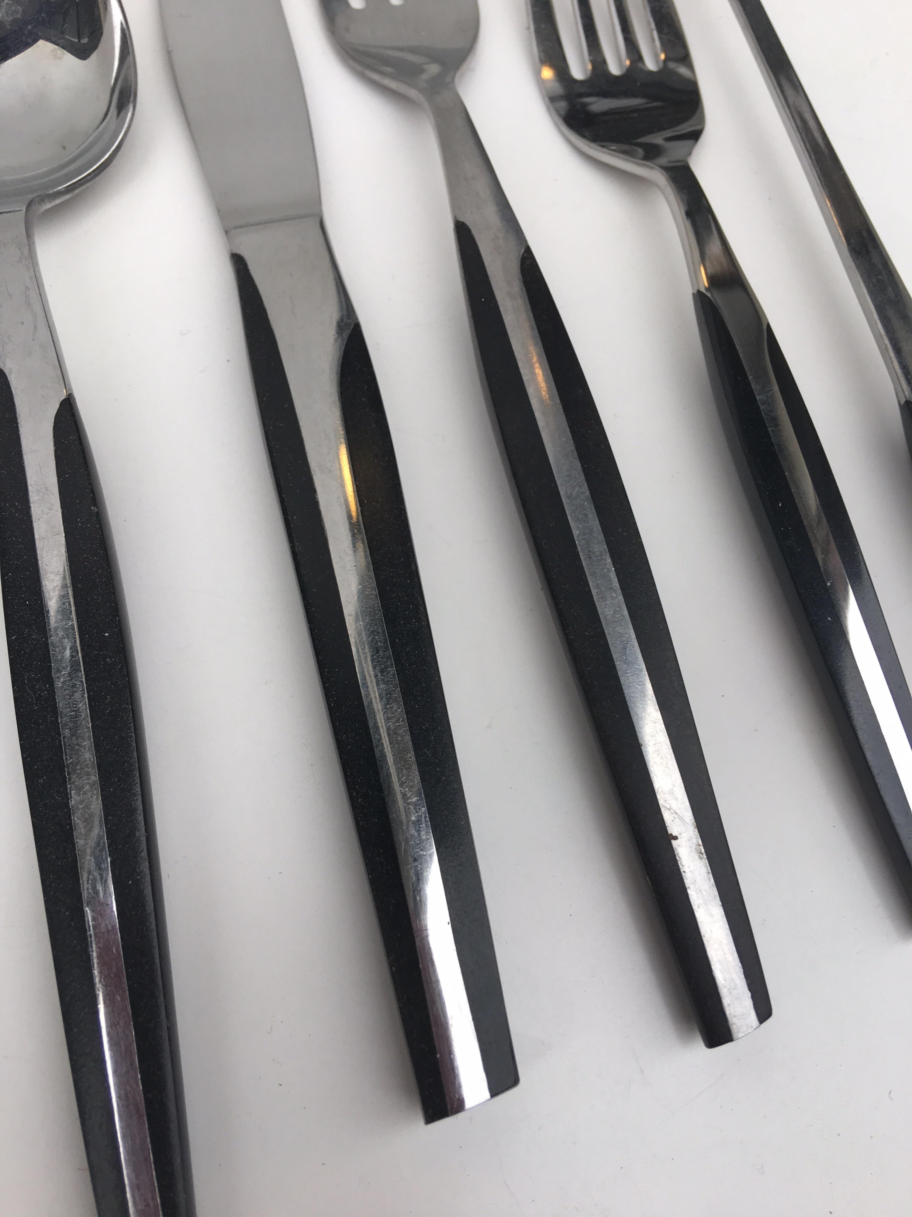 Eldan stainless steel flatware with ebonized handles made in Japan. Very extensive complete seven piece place settings for ten with nine serving pieces and a few extra. Total of 87 pieces.