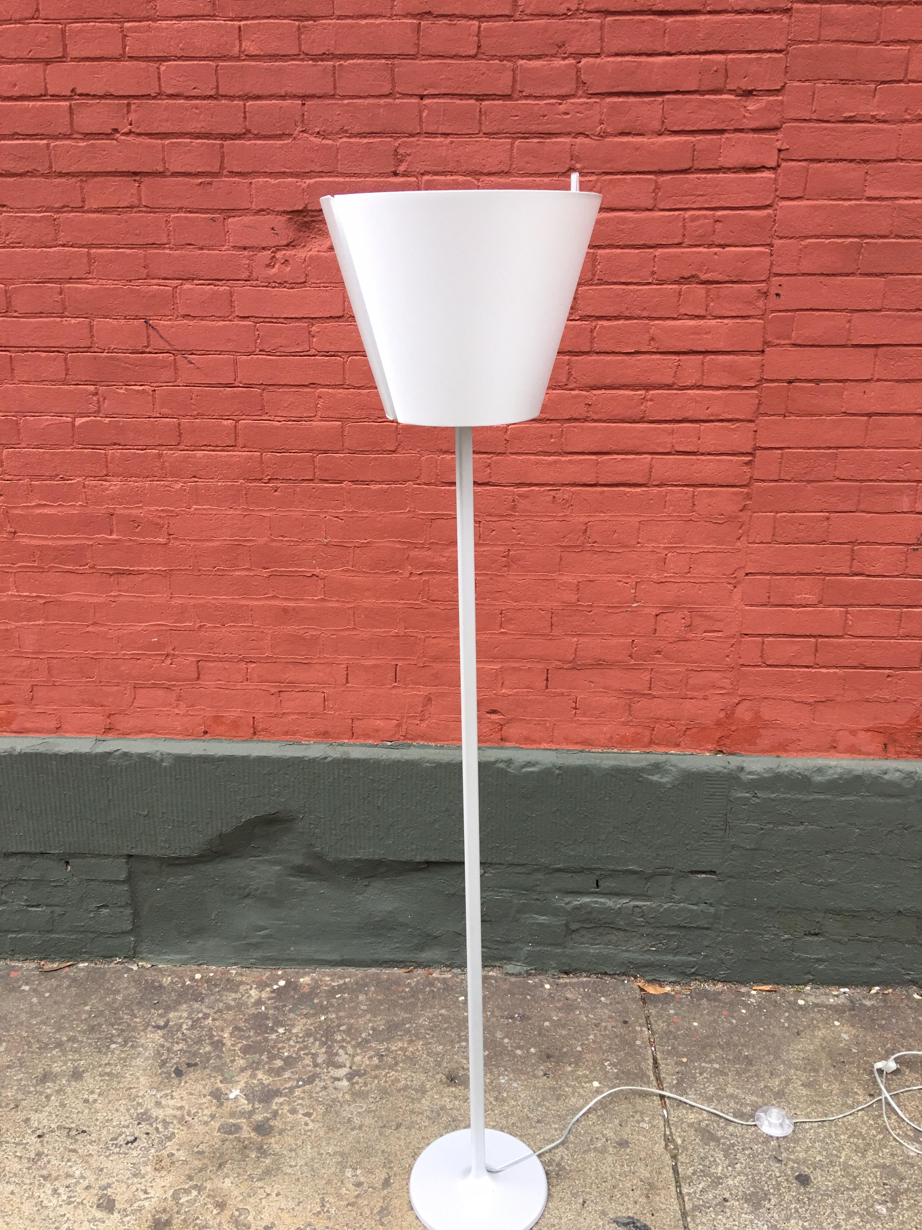 Artemide Melampo by Adrien Gardere adjustable position floor lamp. Aluminum lamp with silk shade can be a reading lamp at a complete down position or at a 30 degree angle. In addition it swings up to create a torchier to illuminate an entire room.