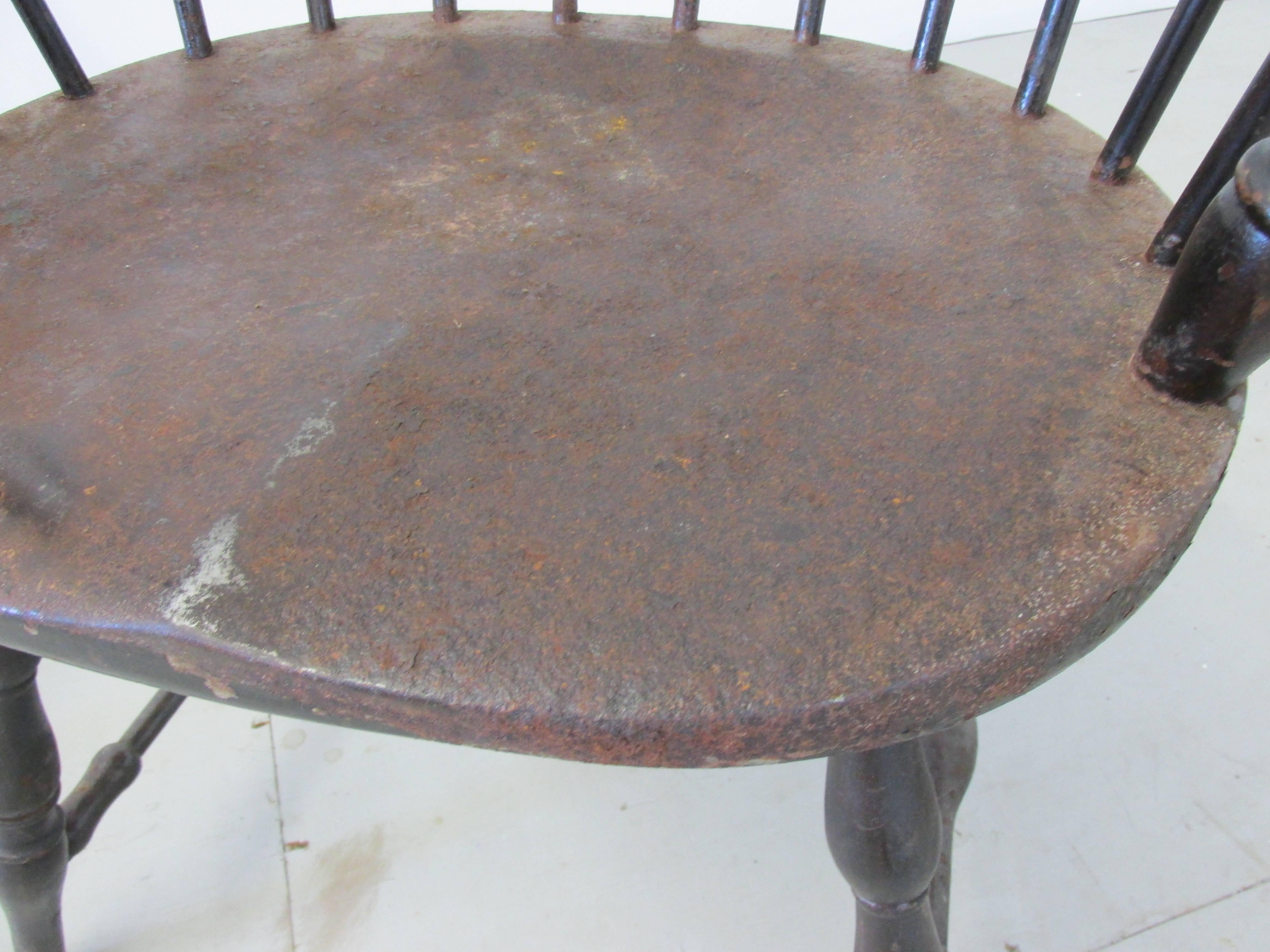 Pair of metal windsor chairs by Canton Art Metal Company of Canton Ohio. Produced in the 1930s. This pair shows loss of paint and surface rust, but originally had a faux wood grained finish. This pair is said to be from the Philadelphia Main