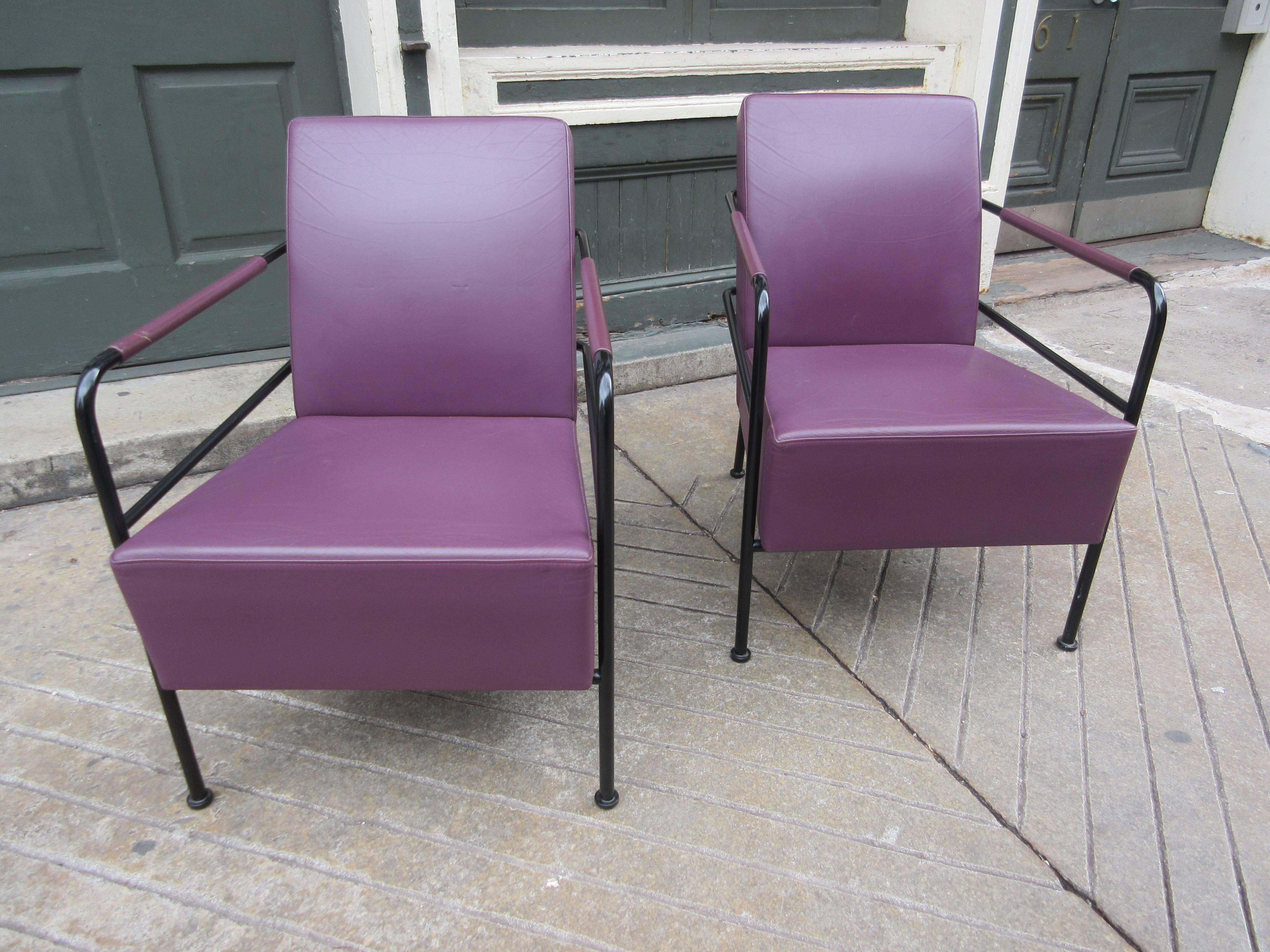 Pairs of petite armchairs in plum leather with painted steel structure and leather wrapped arms. Both chairs have their Lammhults labels.