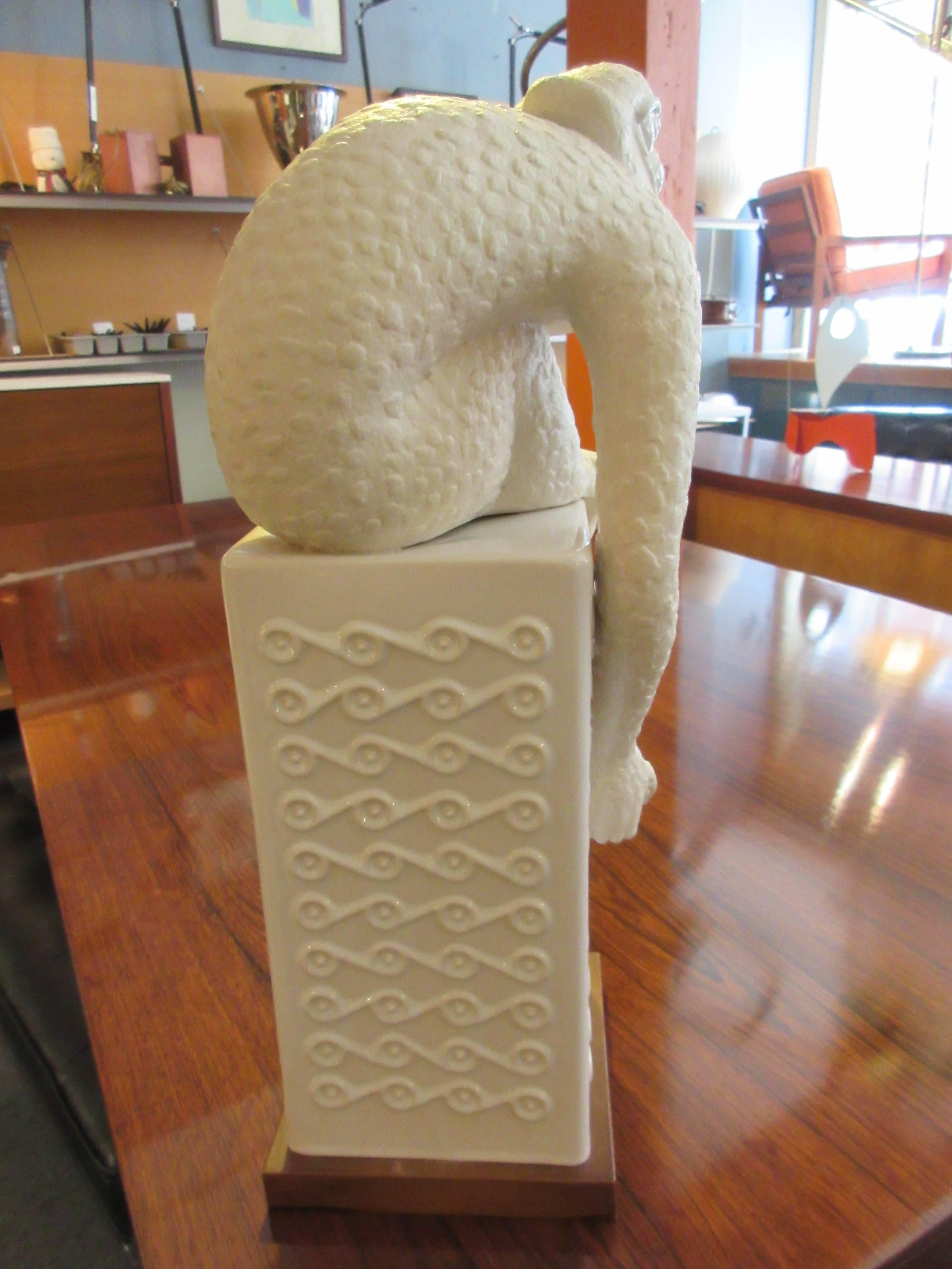 1950s large monkey in porcelain sitting on a decorative column also of porcelain. We believe it to be German. It is unmarked.