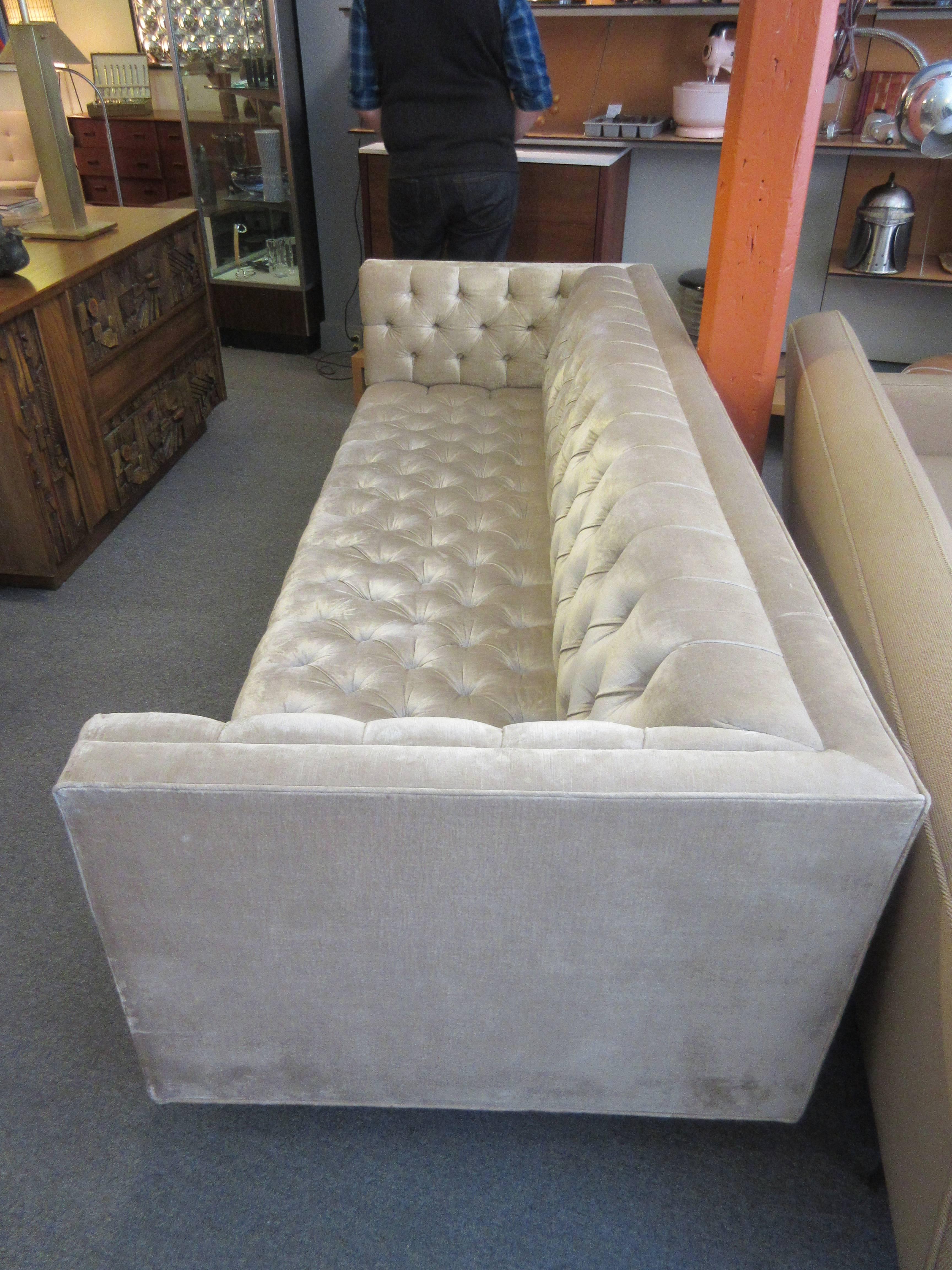 Three years old and never used in champagne velvet with wooden frame and hand tied springs gives a modern twist to the classic Chesterfield form. Thin square steel legs make it seem to float over your floor.