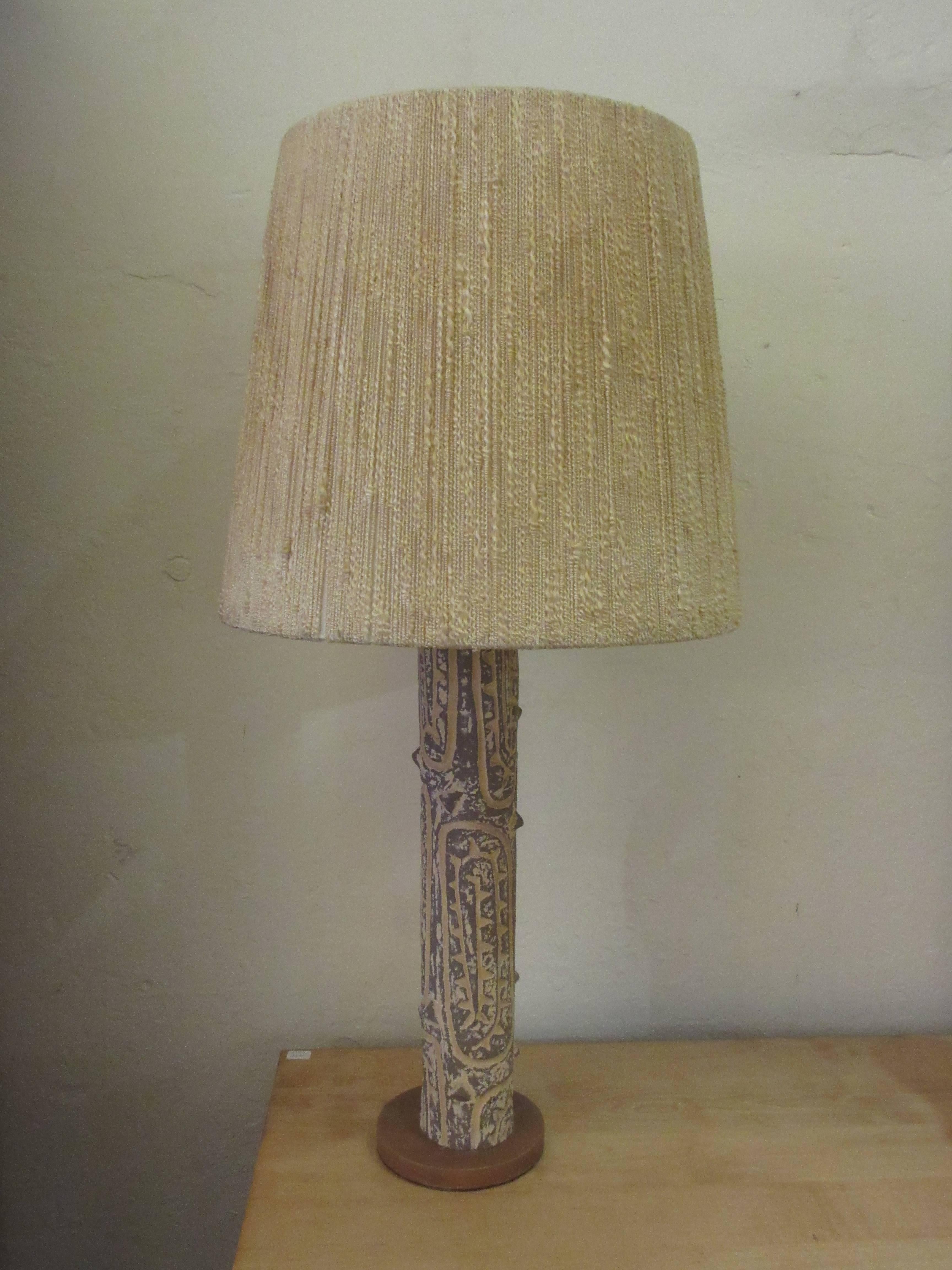Unusual, tree trunk stylized table lamp with original shade. Ceramic lamp sits on a round wood base. With shade, lamp is 30