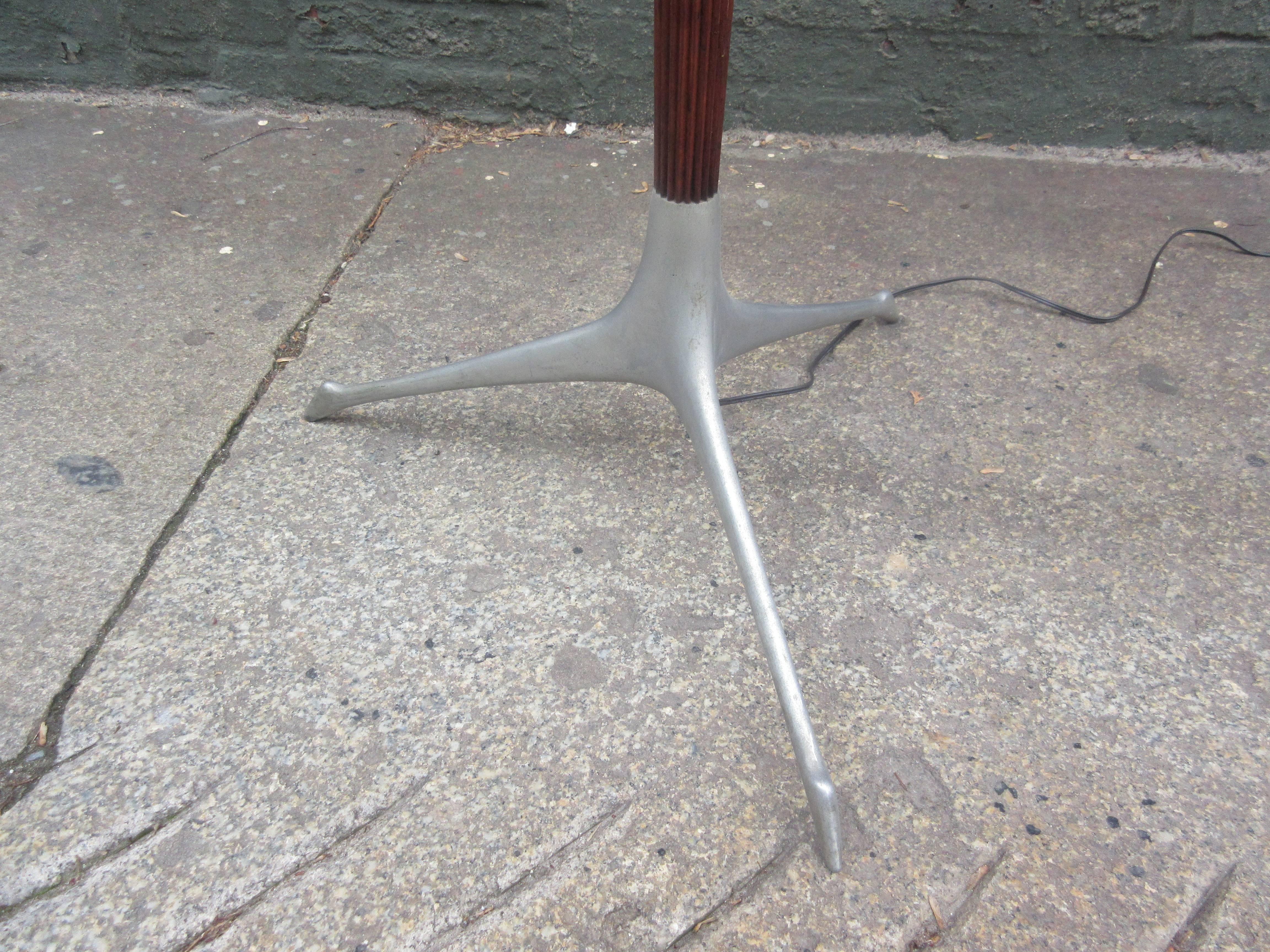 Hard to find tri-symmetric floor lamp designed by Kagan in 1958 and produced by Kagan Dreyfus NYC. Lamp base is cast aluminum with a wood fluted stem. Takes a large three-way bulb.