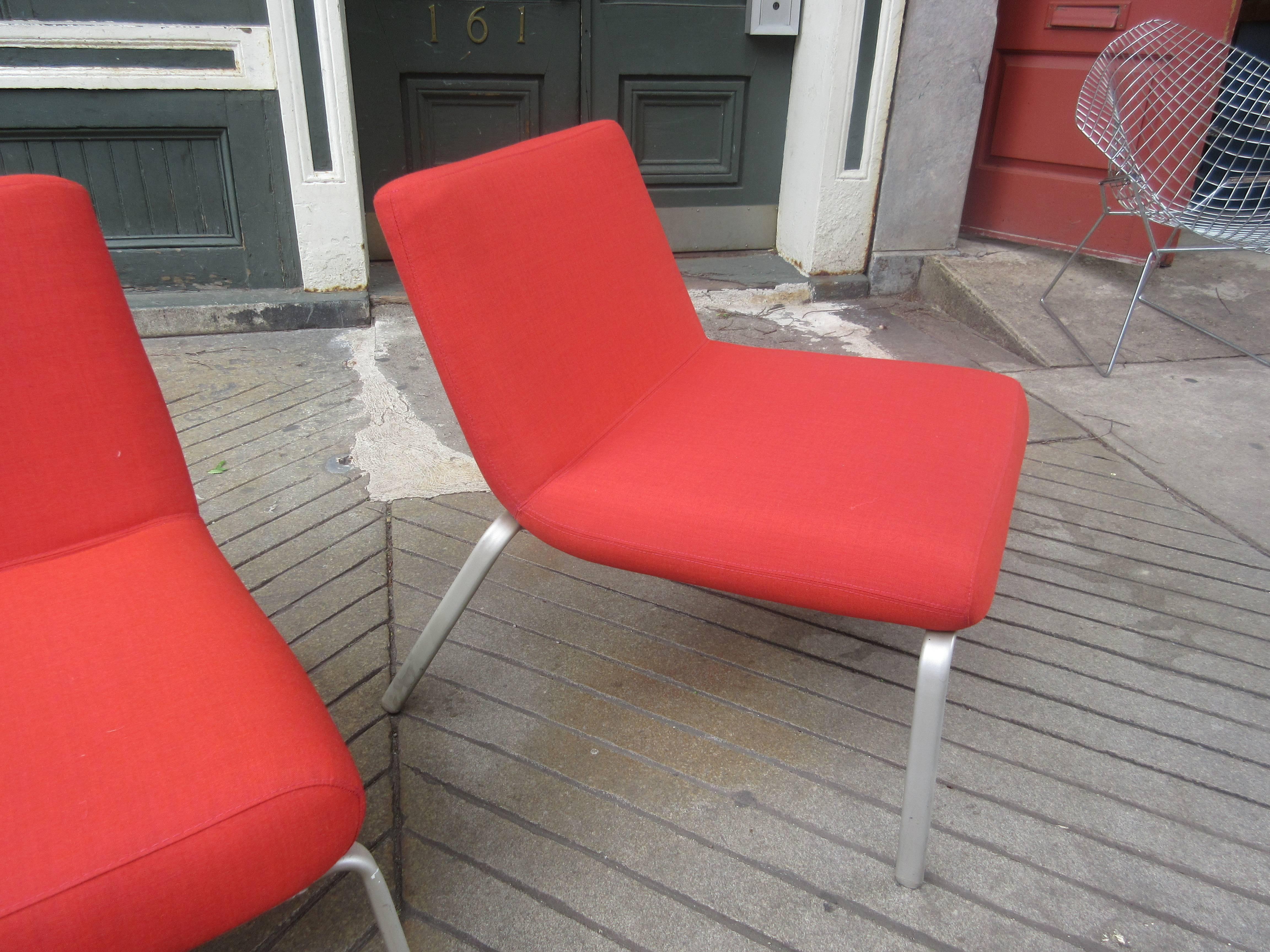 Newly upholstered pair of Celia chairs designed by Mark Kapka in a tomato red fabric.