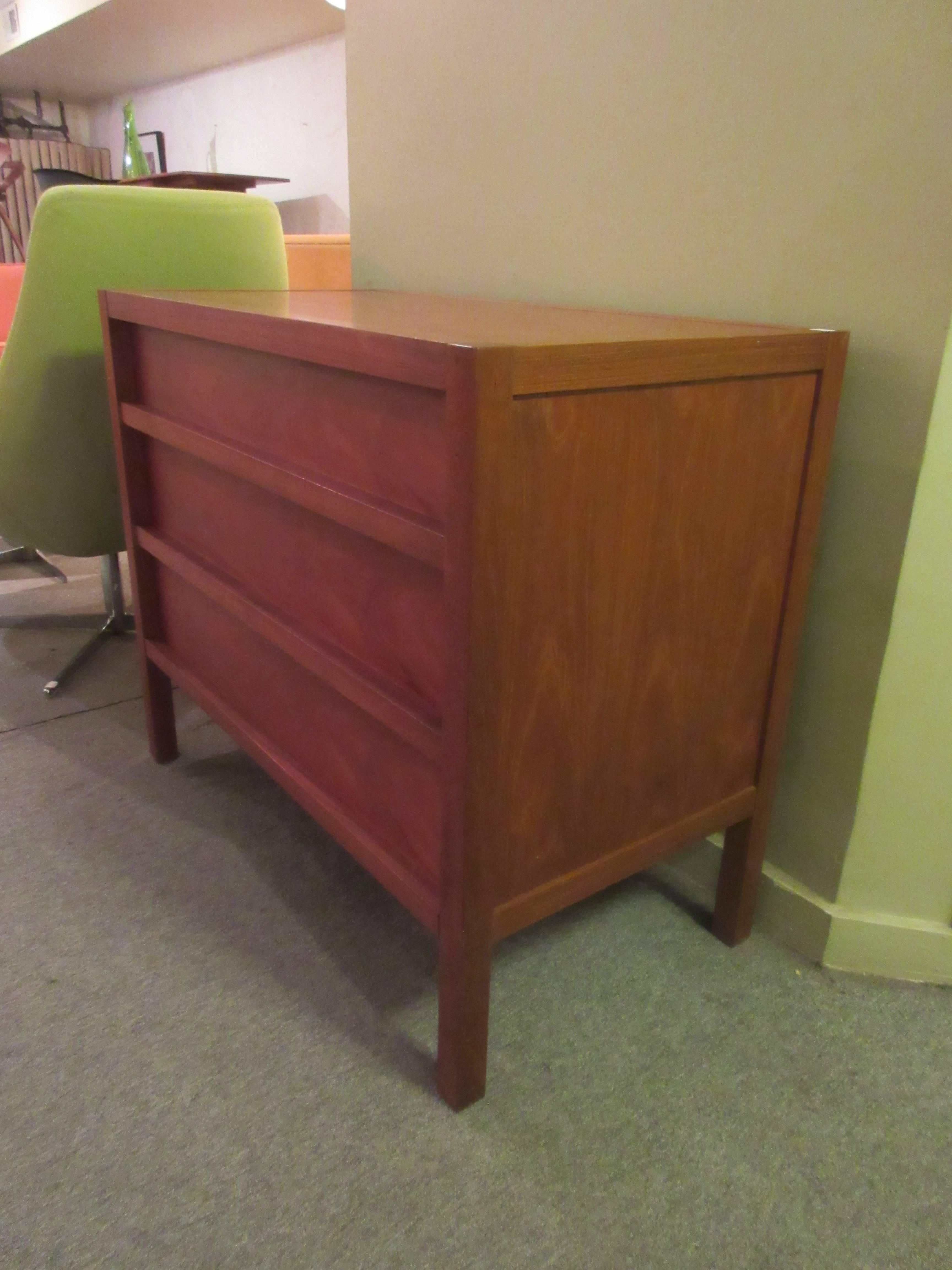 Solid and veneer of teak three-drawer dresser. Drawer pull is of solid teak that spans the entire length of the bottom of the drawer. We have a longer six-drawer matching dresser.