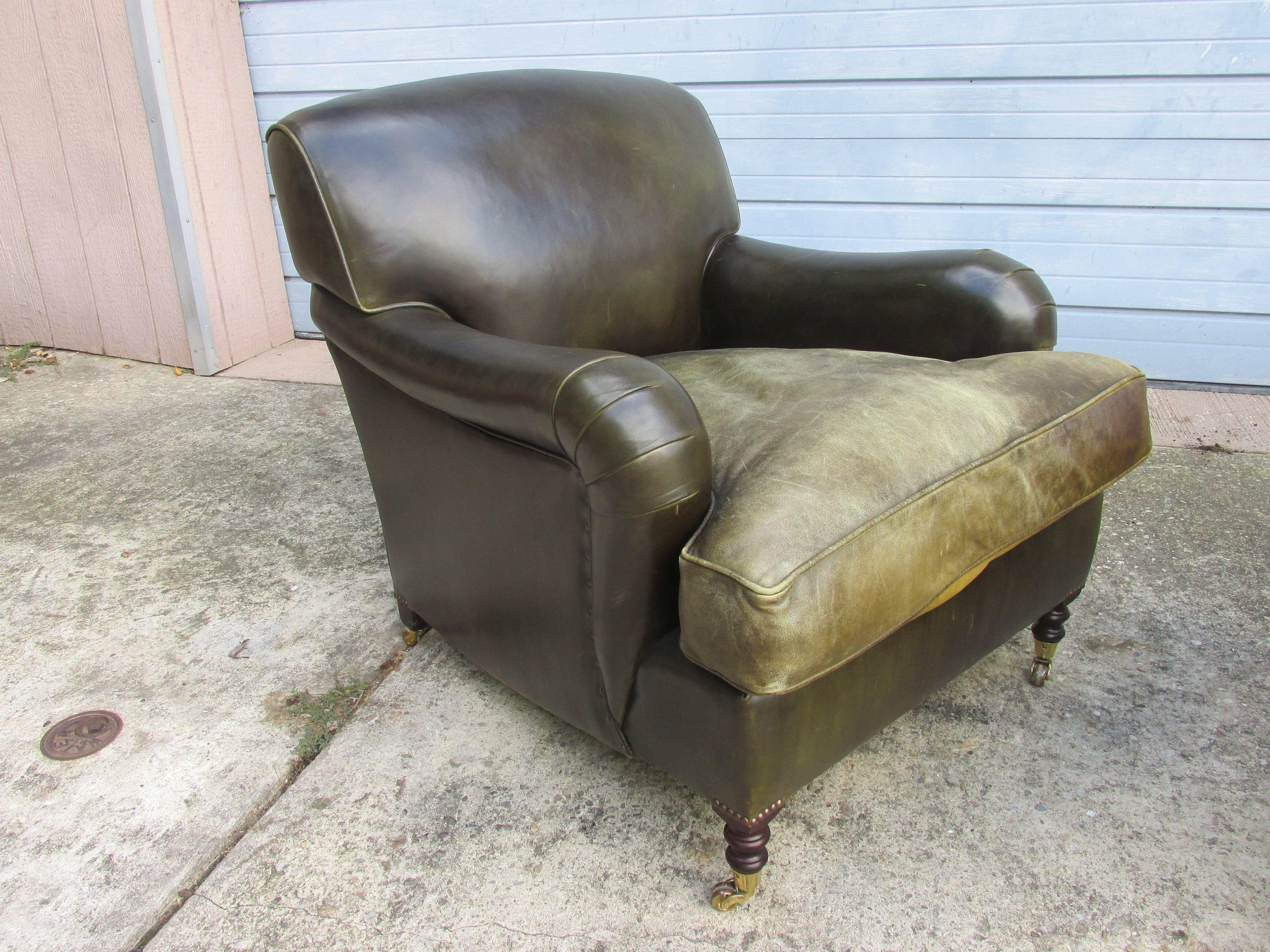 Nicely aged George Smith armchairs in a dark green leather, with perfectly worn leather down cushion seats, circa 1995. Nice turned legs with brass casters. Extra deep and very loungy! Retains original labels. Ottoman from the same house also