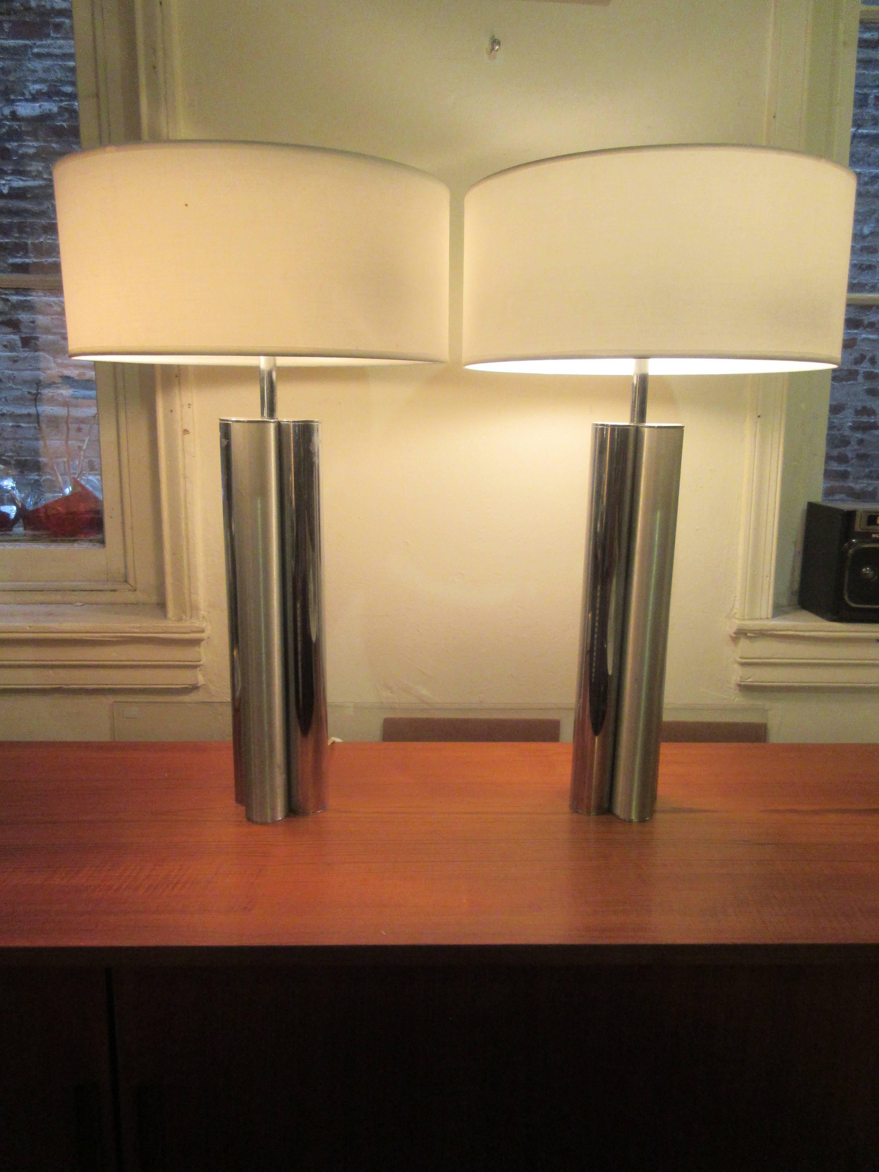 Pair of mutual sunset lamps retaining label. Four columns making the stem of lamps are alternatively polished and burnished chrome. Shades are new white linen. On and off switch are on the cords.
