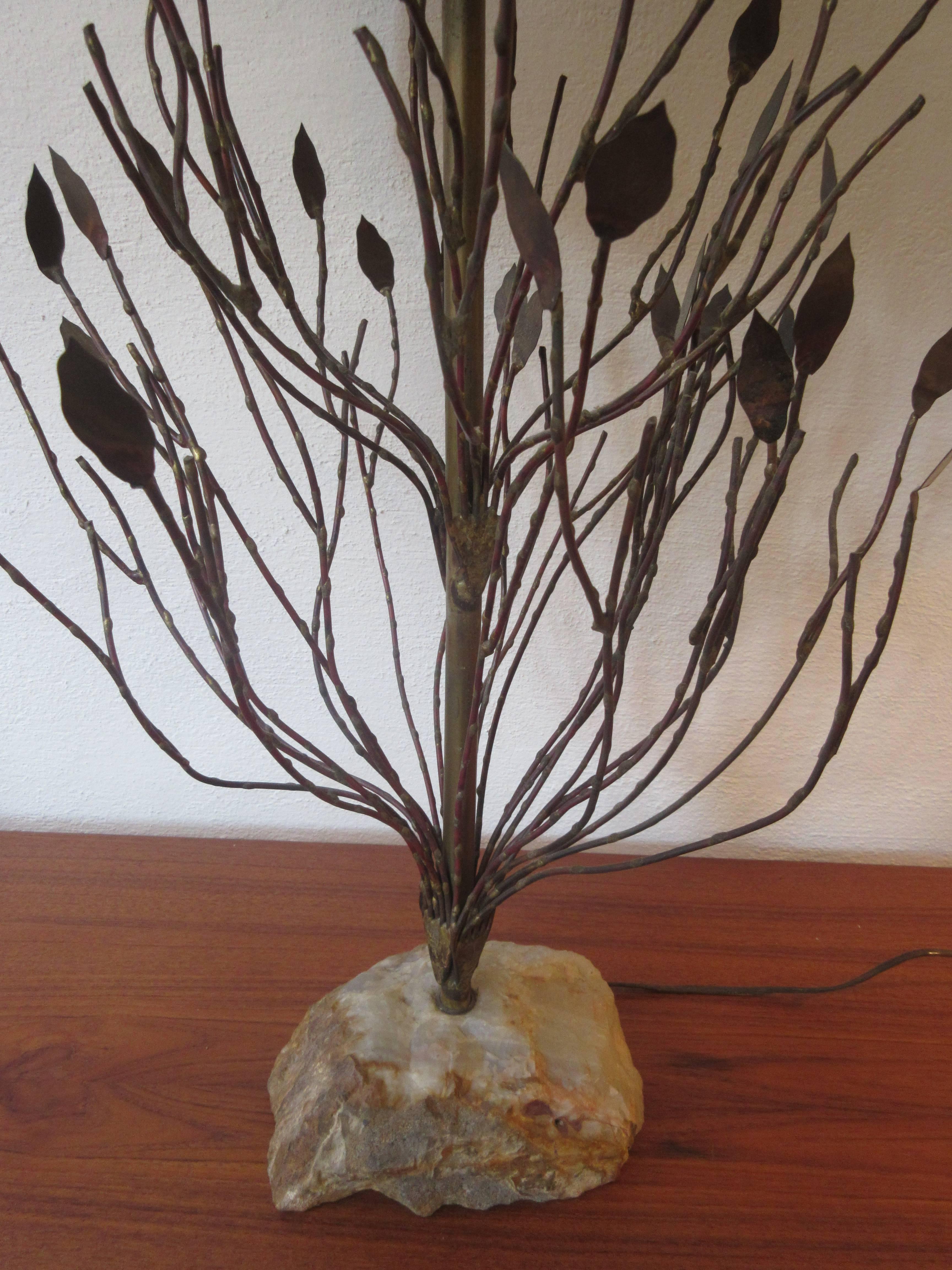 Unmarked lamp in the style of these two American metal workers. Bought from Home of the original owners in Philadelphia decorated in the late 1950s. Metal tree sprouts from a rough hewn rock and lamp sports the original burlap shade.