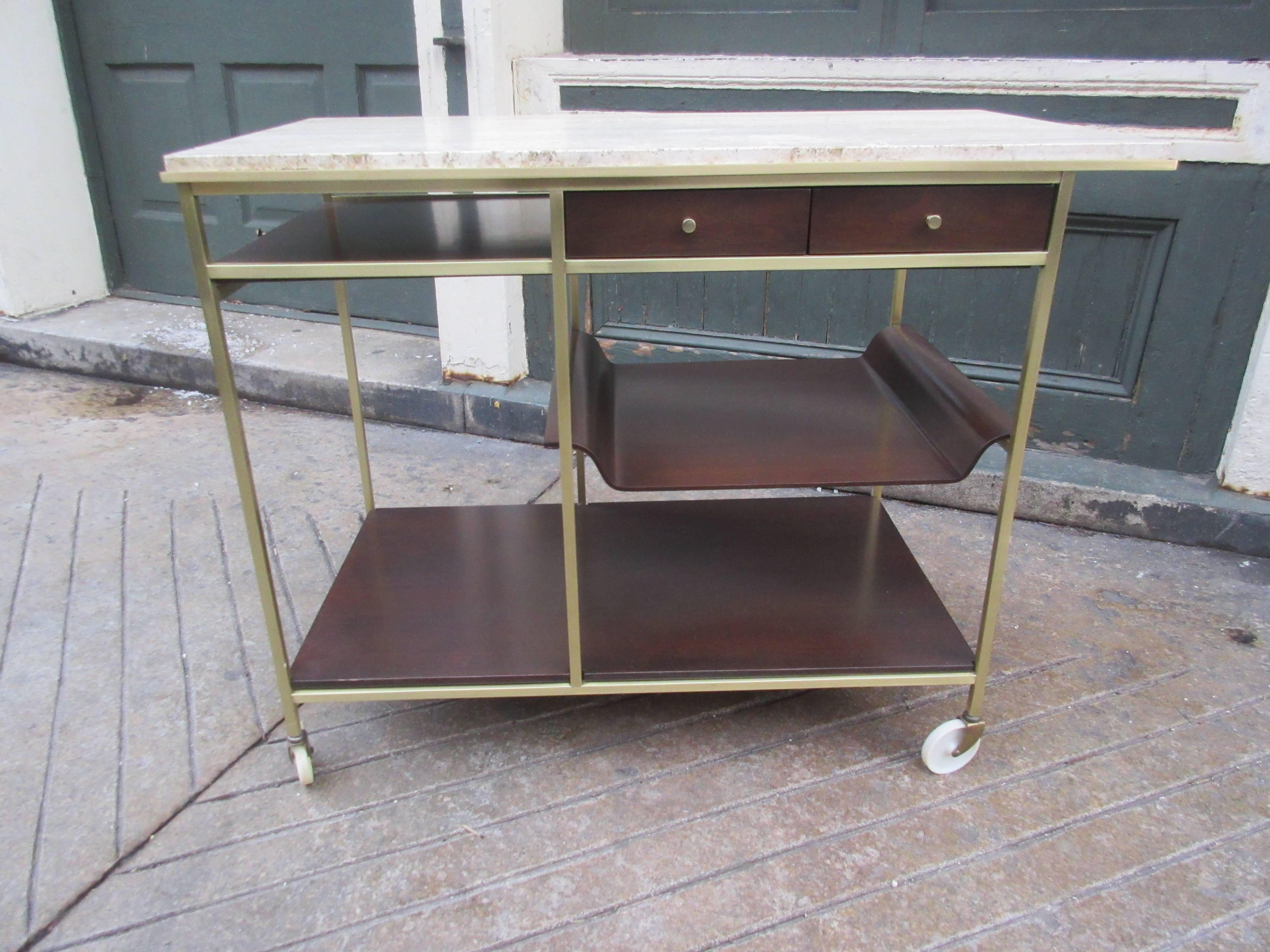 Elegant walnut and brass bar cart with original travertine top. Removable molded plywood shelf doubles as a serving tray. Walnut just refinished and brass polished. Pull-out shelve provides additional work space. Bought from original owner.