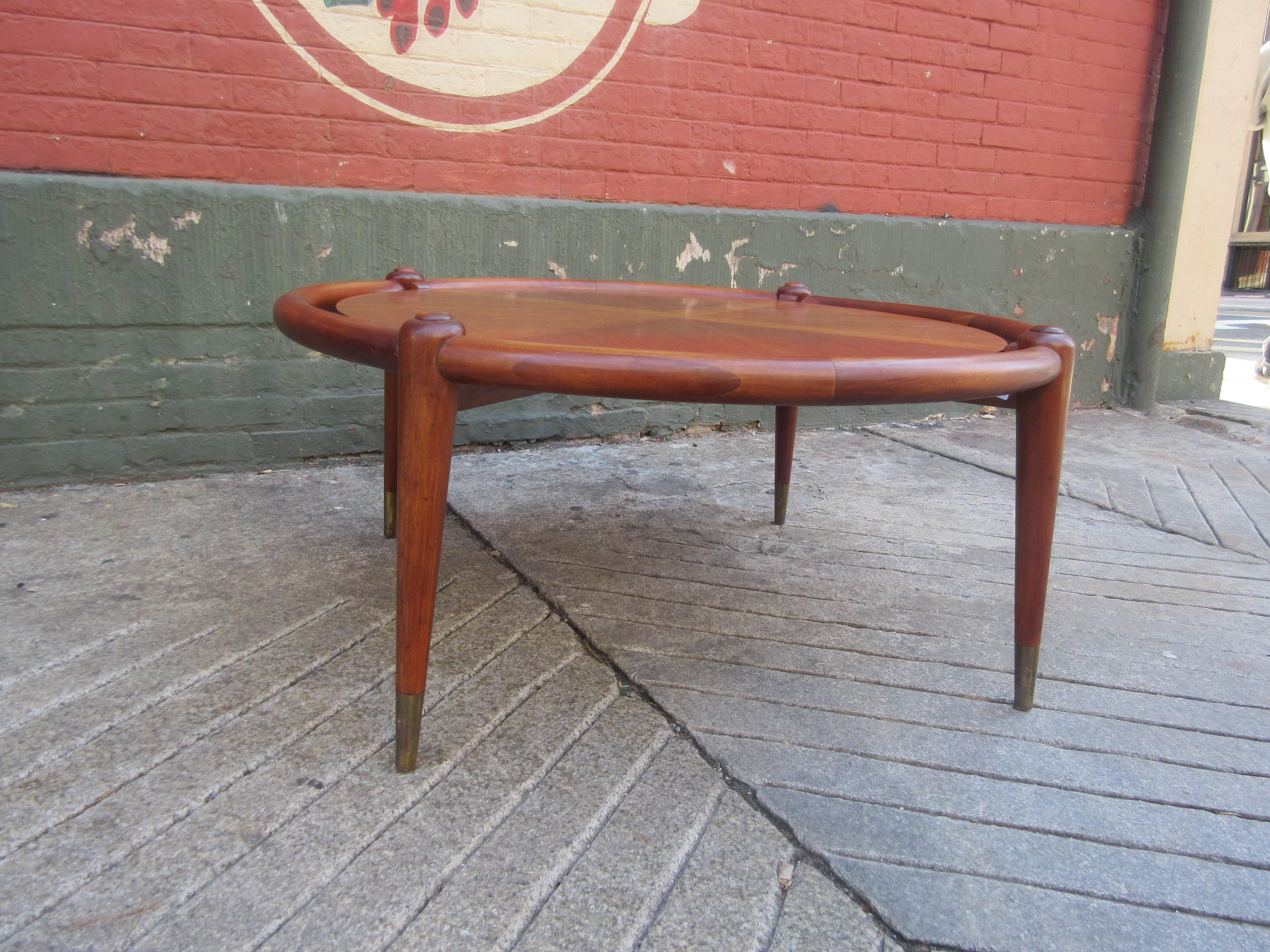 John Widdicomb coffee table with both Widdicomb and Goldsmith's label (prominent Philadelphia Furniture Store). Tapered legs are capped in brass and inlaid round floating top has an X with in a circle design.