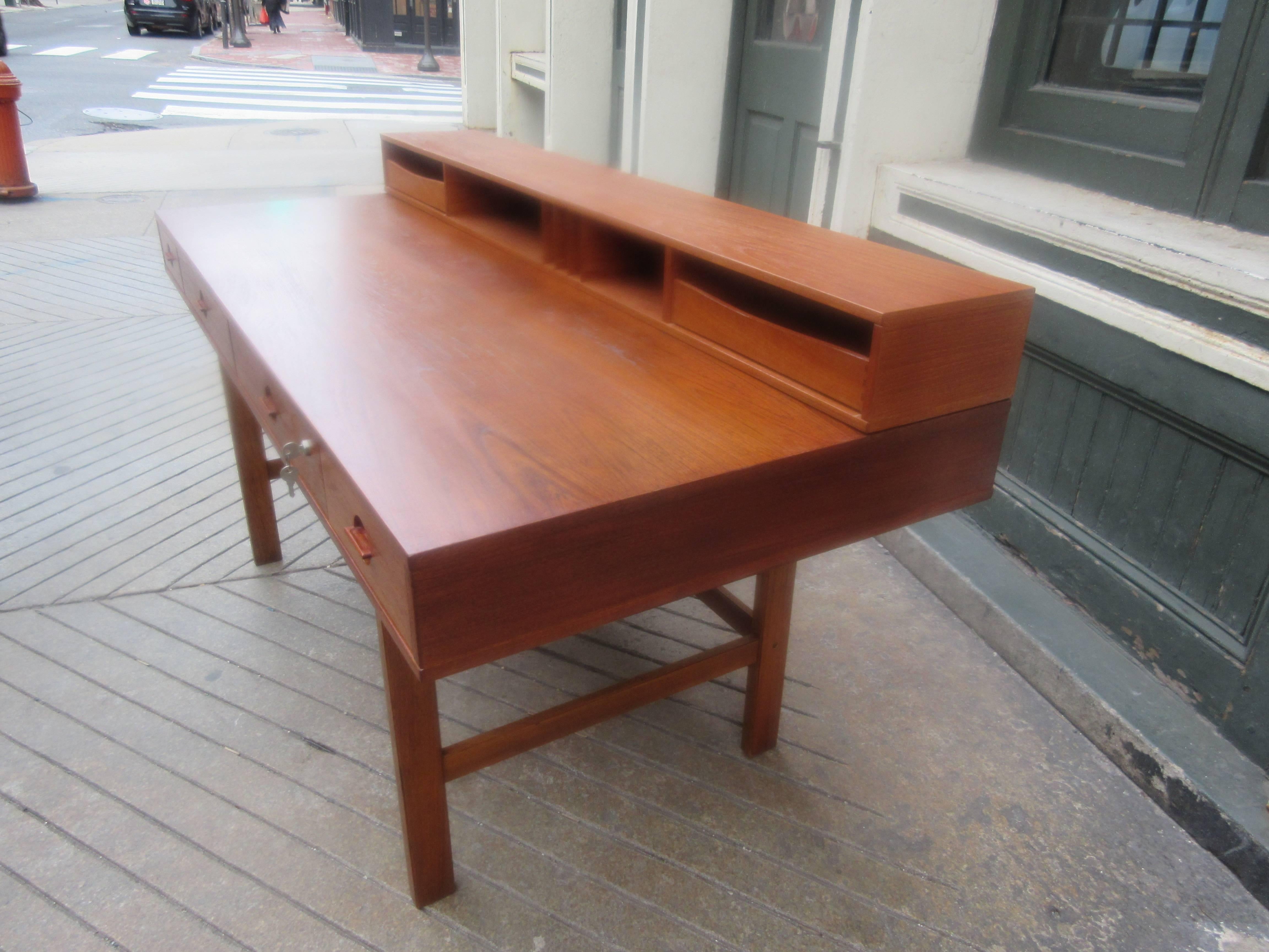 Late 1960s Løvig teak desk in very nice condition! Retains it's labels and original key. Upper Cubby Hole Section folds down to make a deeper work surface when needed. Two sliding dovetailed boxes slide out from cubby area. Most often attributed to