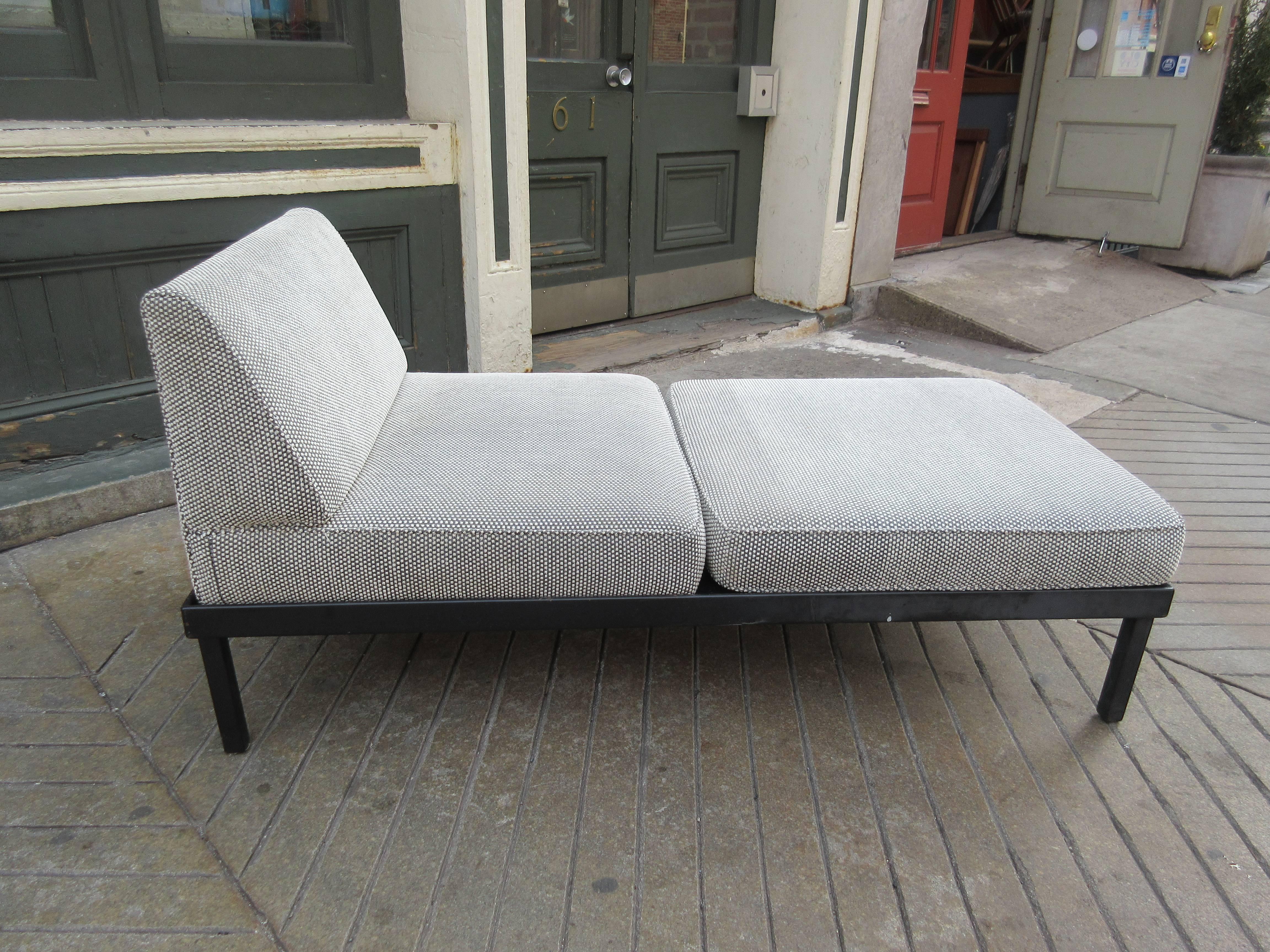 Interesting platform bench with a single cushion and a backed cushion. Both cushions are removable and held in place by a small ridge and gravity on the metal legged wood platform which allows several seating combinations. Fabric is a black