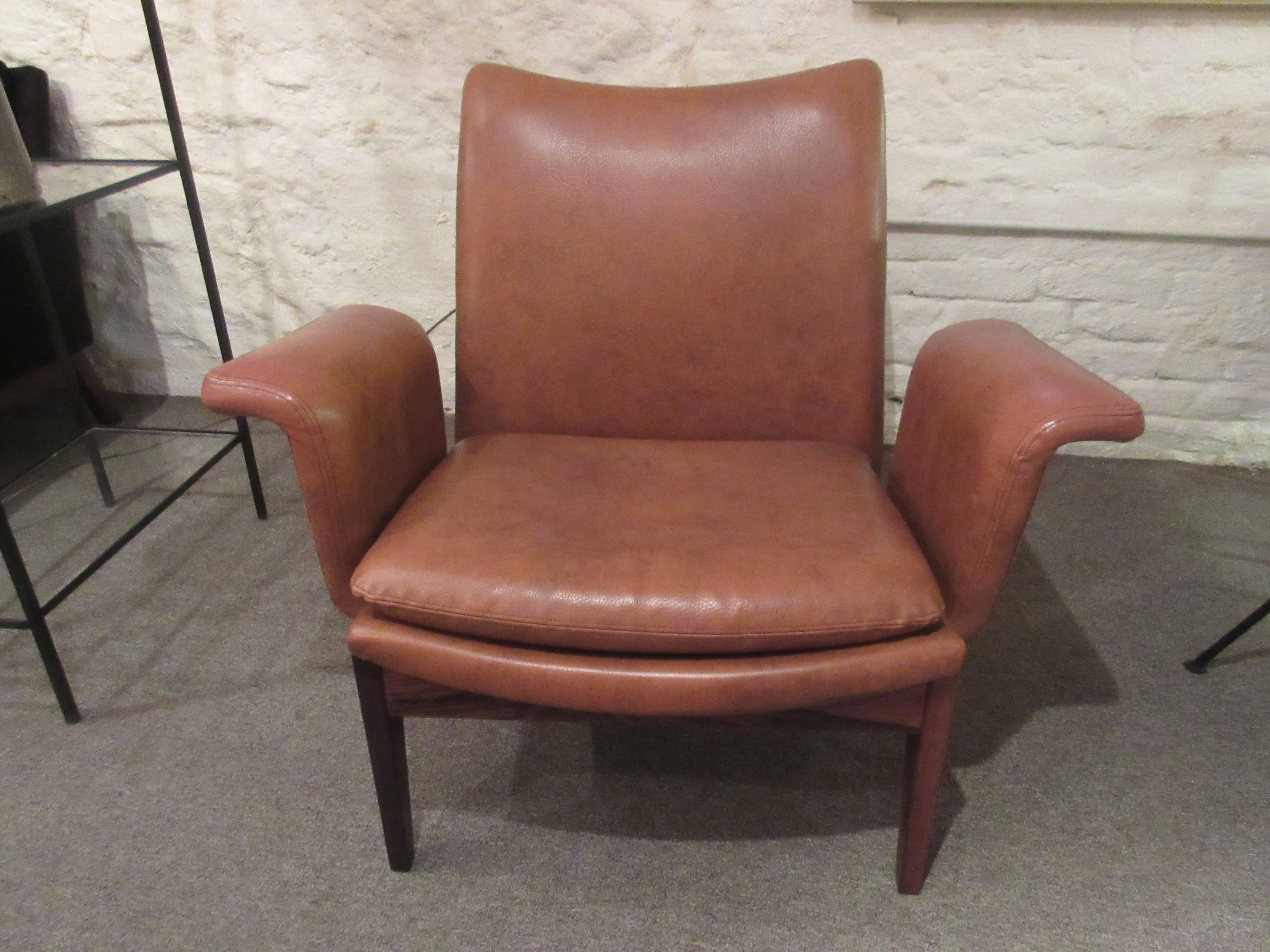 Finn Juhl for France and Sons rosewood armchair in original brown vinyl. Back and arms made of flexible plywood giving a spring to each. Supports are solid rosewood and the gentle curve of the rear support is especially graceful. Danish furniture