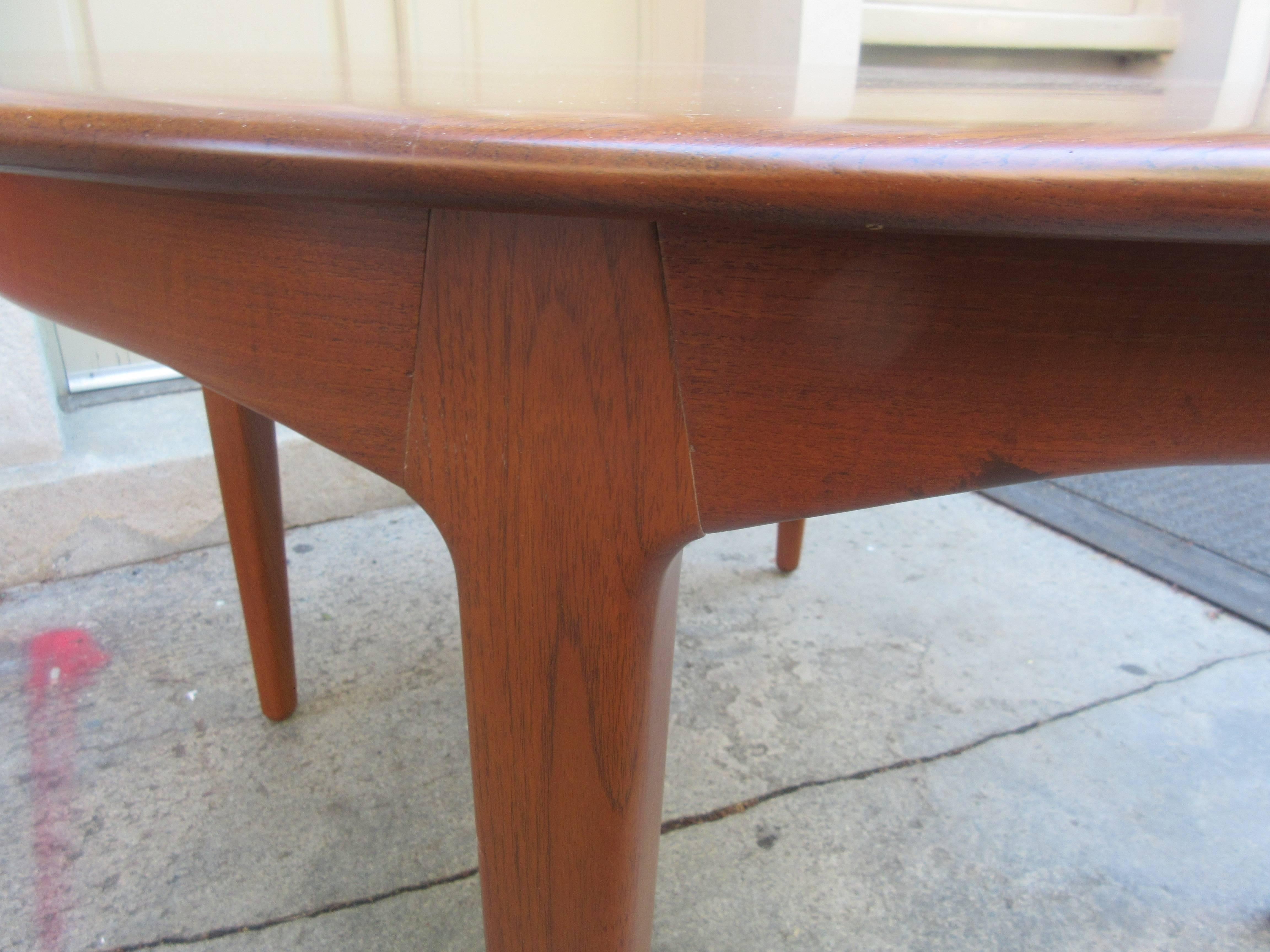 Beautiful newly refinished Henning Kjaernulf teak dining table with an amazing complete skirt, even when leaves are put in place! Additional four leaves measuring 19 3/4