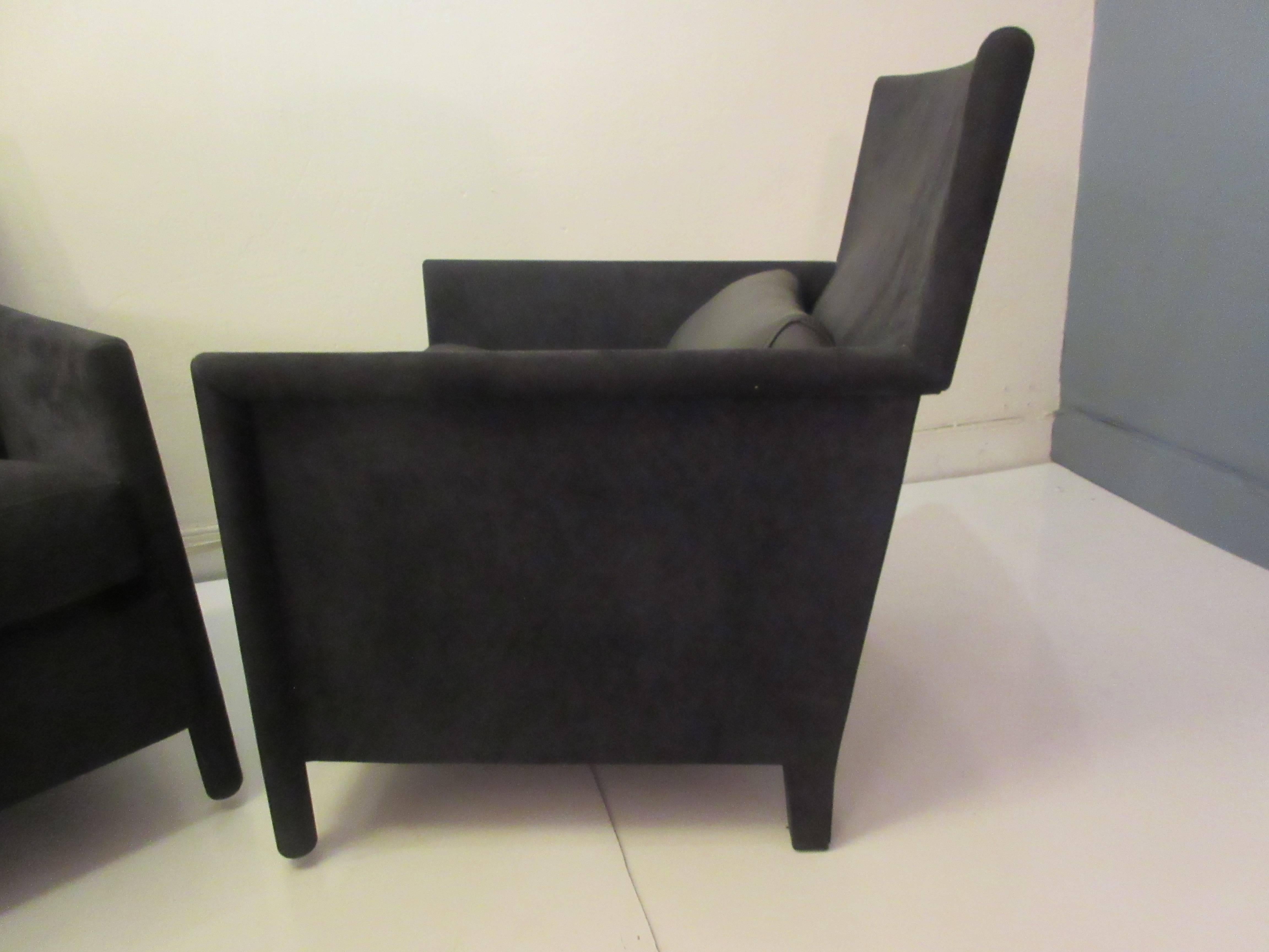 Molteni leather armchairs in charcoal suede with a black leather bolster lumbar cushion. Chairs are completely covered by leather including legs giving a smart tailored appearance. Each retains a label. Chairs are 1990s editions of this venerable
