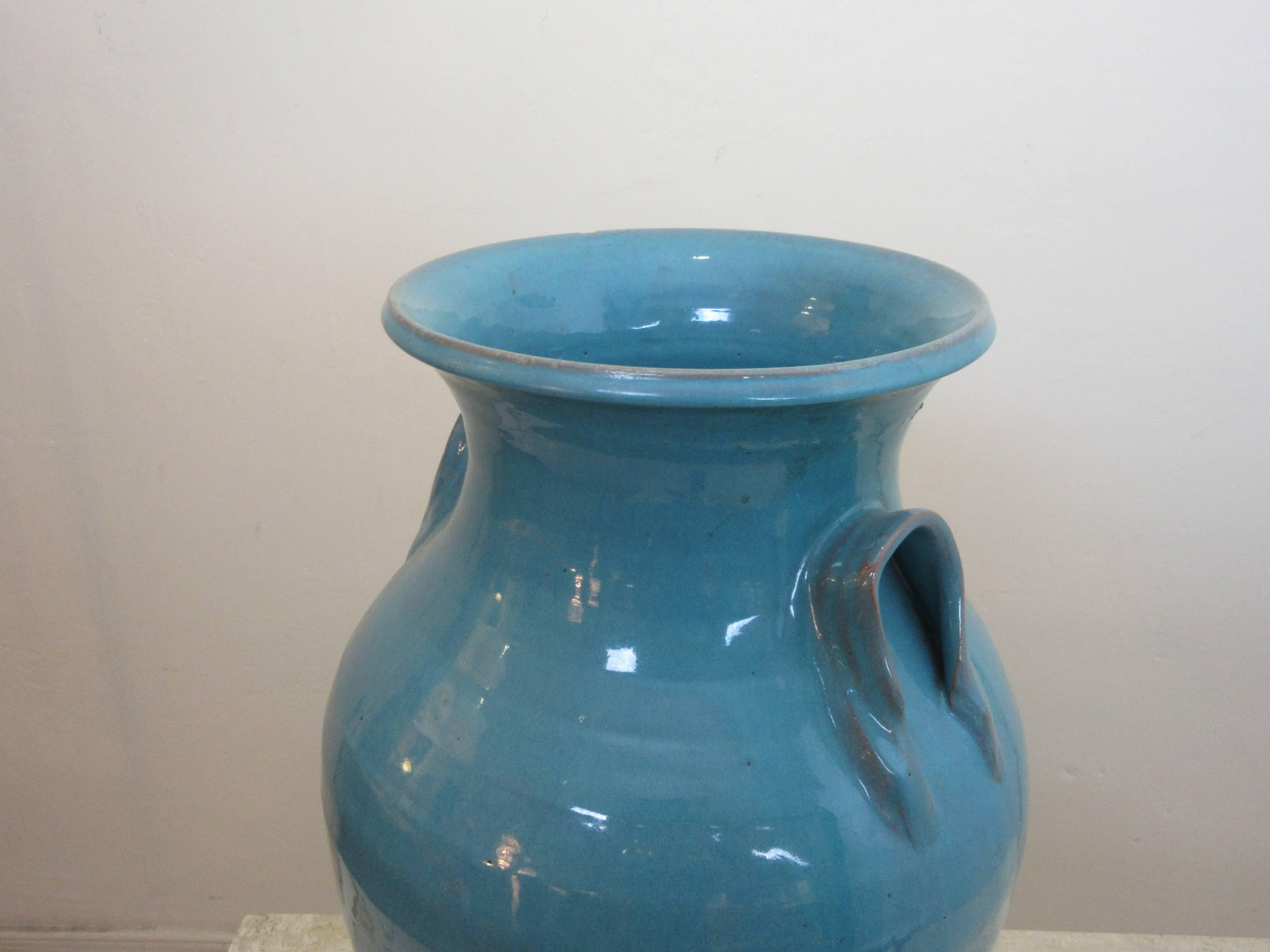 Hand-Thrown urn with a blue-green glaze. Nice size and shape! One factory flaw to edge, shows a little deformity under glaze.