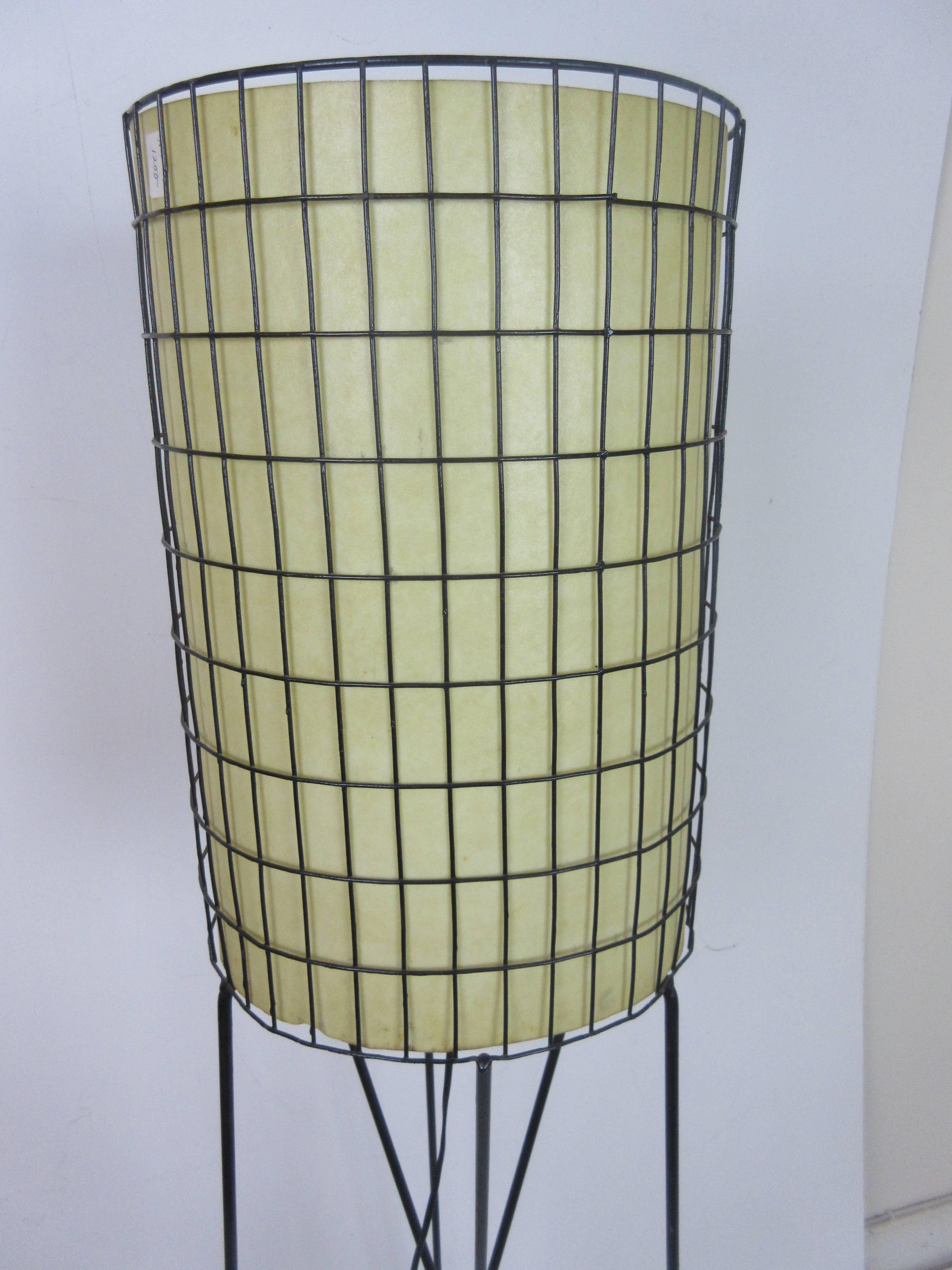 Paul Mayen lamp in wrought iron with fiberglass shade. Hair pin legs support this fret work cylinder lined in fiberglass to shield the light source. One of Mayen's early successful low cost designs.