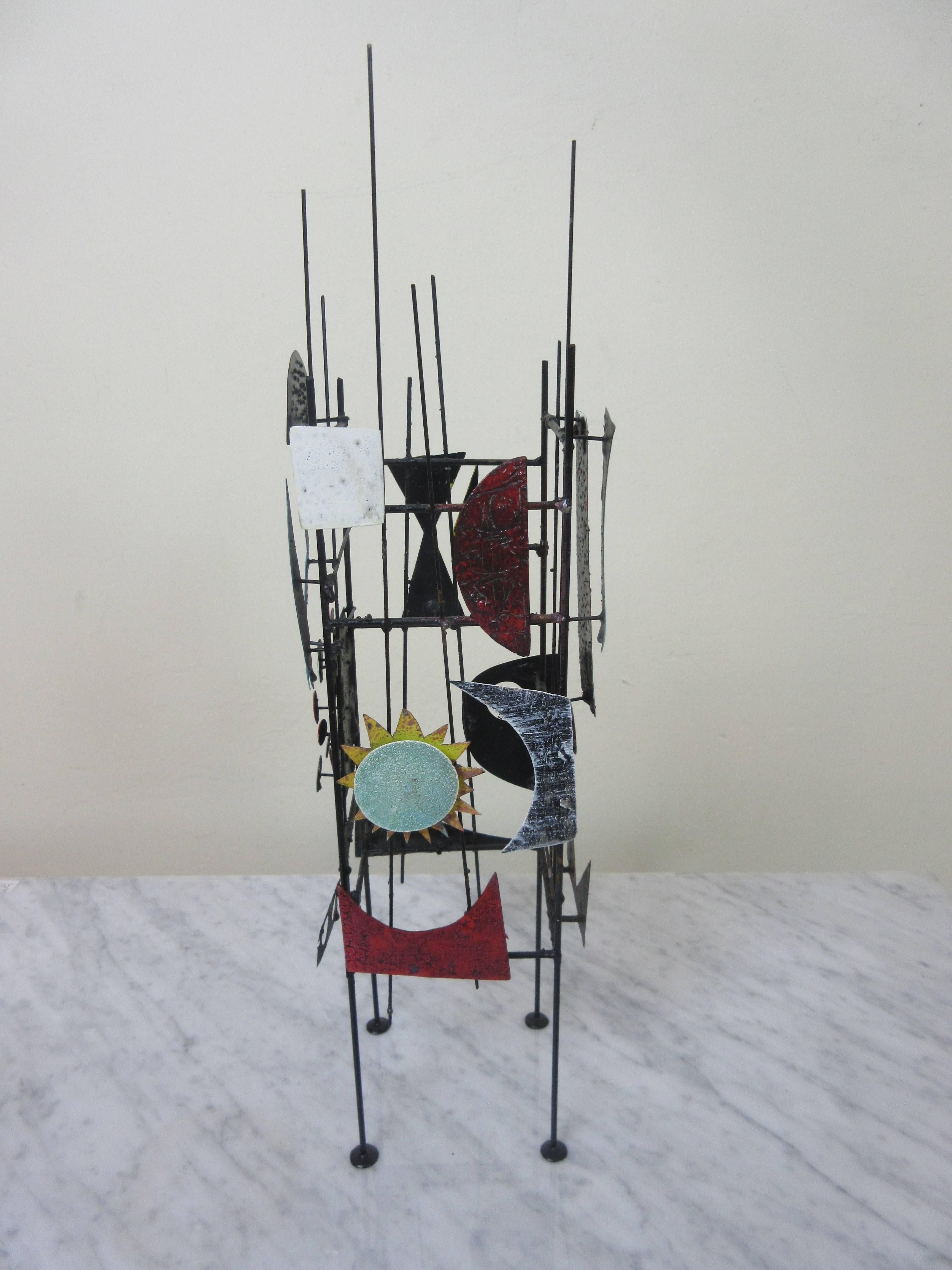 Adam Henderson Sculpture Seascape in metal and Paint 2016. Adam's colorful abstracted shapes in painted metal are suspended by four legs with pod feet. Various painted pieces have symbolic shapes on them and some are cut-out. This is especially good