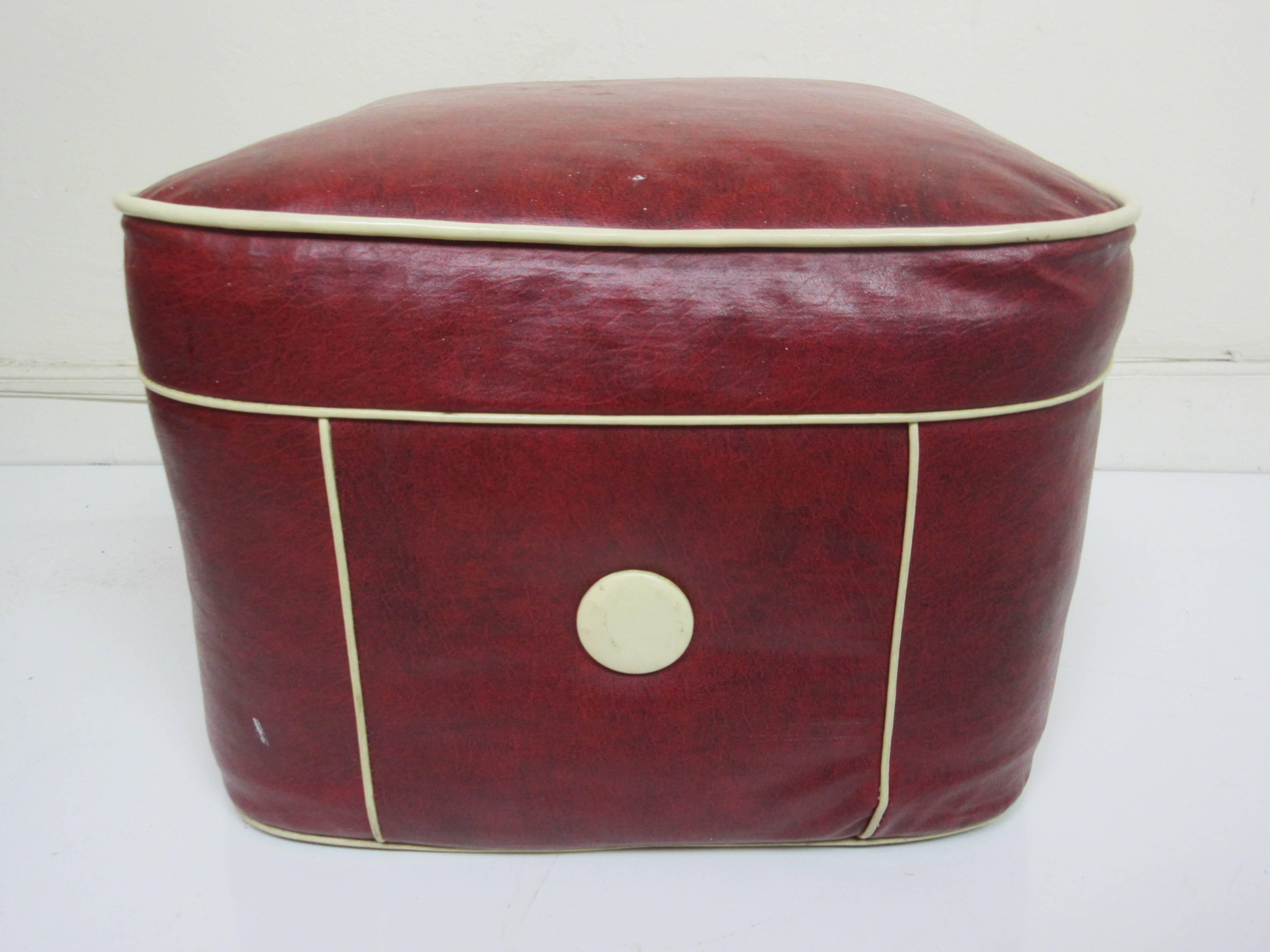 1950s hassock/ottoman in Maraschino red cherry vinyl with white piping. All original with few flaws. Red is vibrant and no stains or fading. Two small missing pieces (pictured).