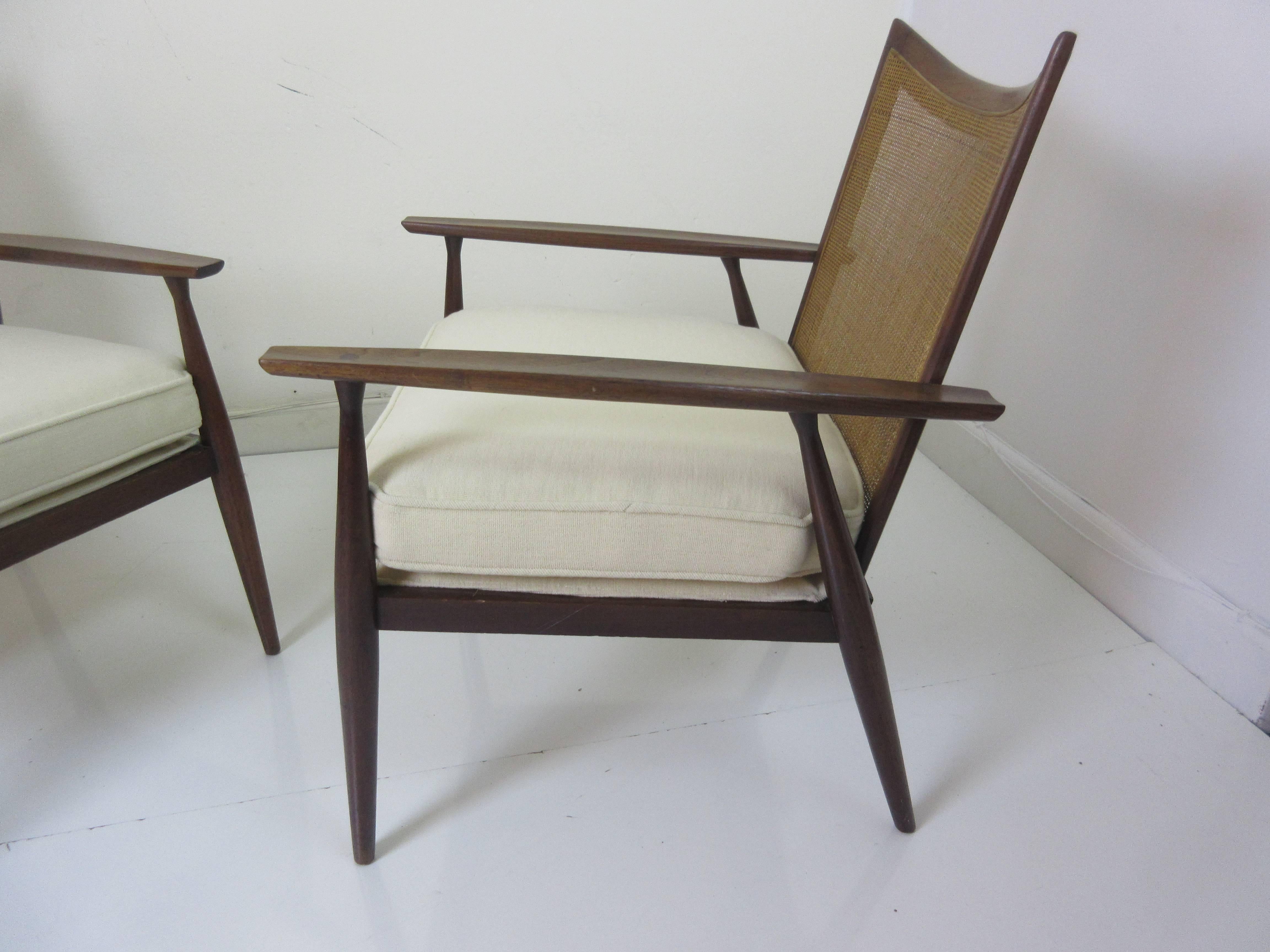 Paul McCobb for Directional walnut and cane armchairs. Gentle curved back and sculpted arms make this one of McCobb most graceful designs. Solid walnut and the caning are original and excellent. New fabric in an ivory frise will wear like iron.