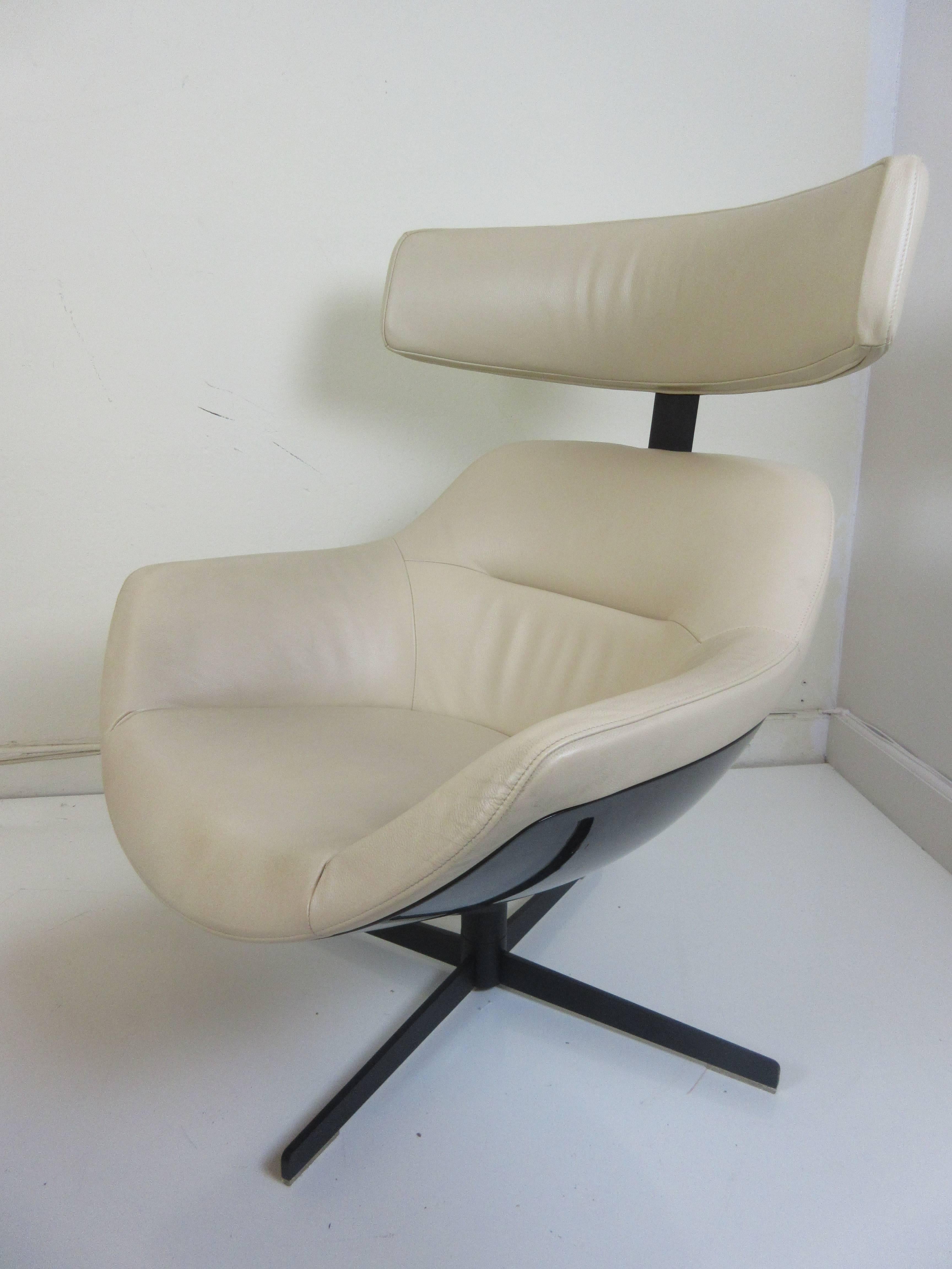 Jean-Mary Massaud Auckland chair and ottoman for Cassina from 2005. Both chair and ottoman swivel and are upholstered in an ivory leather. The head rest has eight separate upward adjustments to accommodate persons of varying heights. Bases of chair