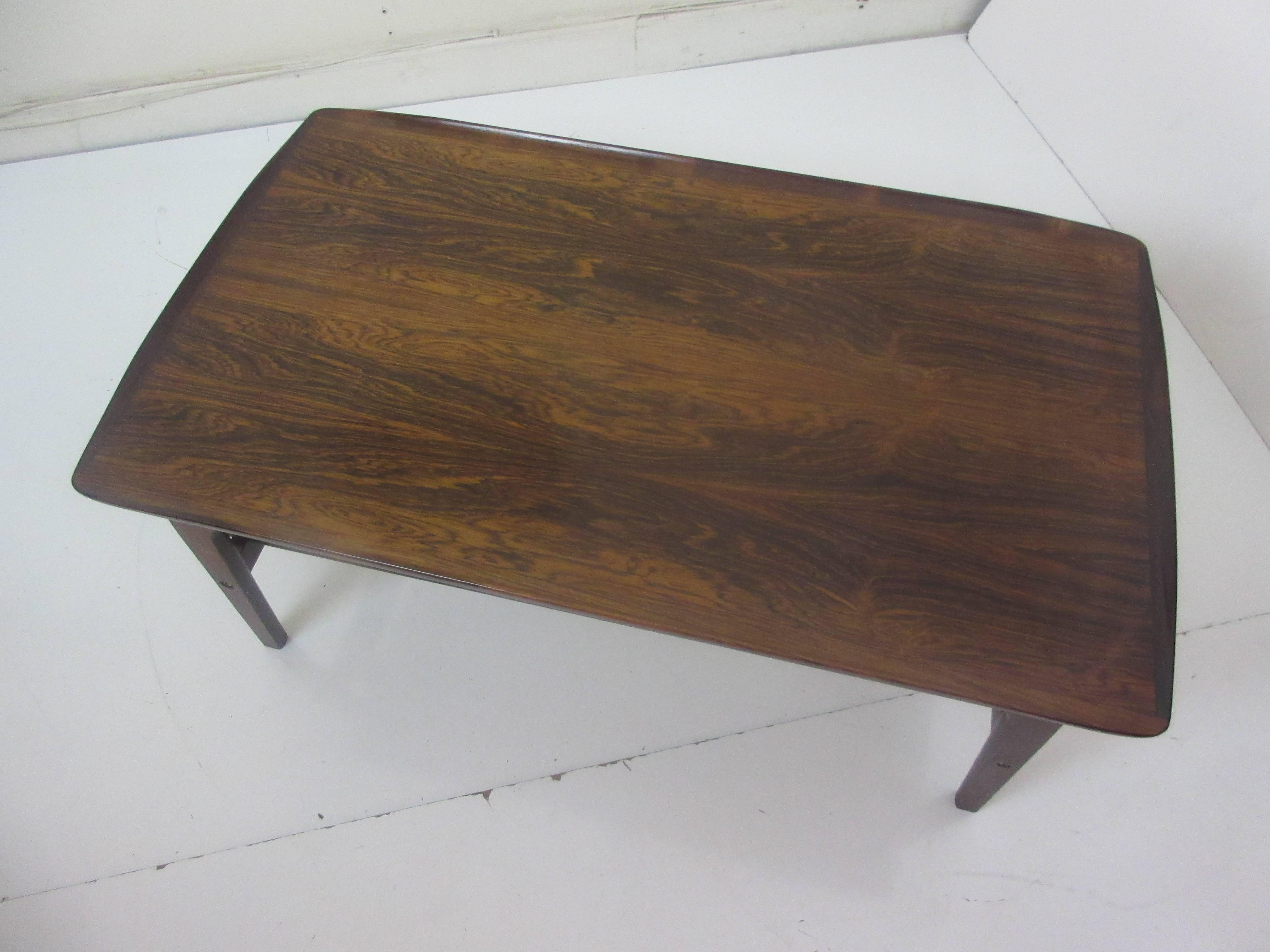 Peter Hvidt for John Stuart rosewood coffee table with canned magazine rack. Rosewood of exceptional graining. Modern piecrust type edge with floating top supported by brass spacers. Canning recently replaced. Bought from original owner,.