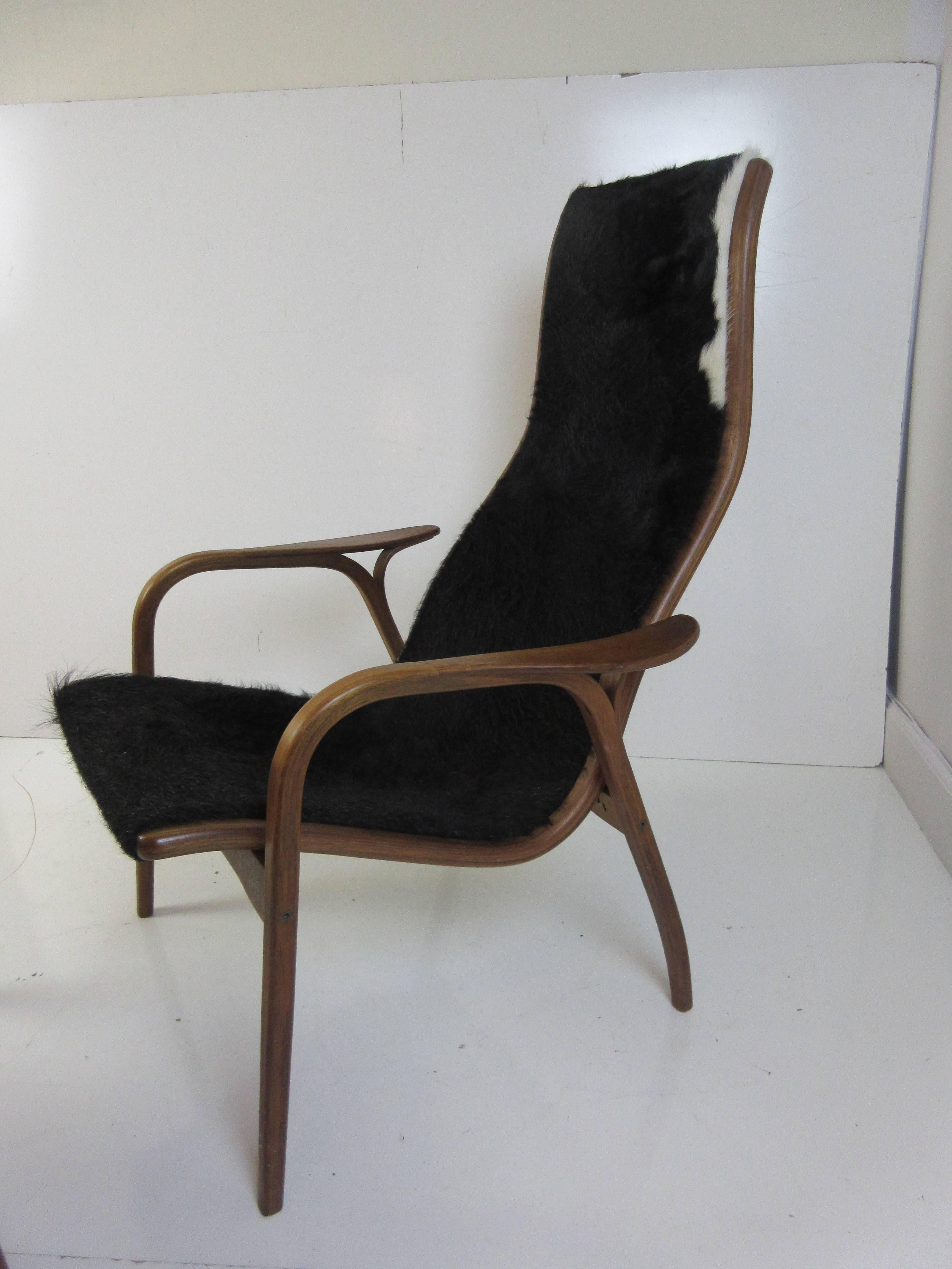 Yngve Ekstrom Lamino chair and Ottoman by Swedese in cow hide with bent laminated teak frame. Cow hide is mostly black with just slivers of white. Chair has burnt in label.