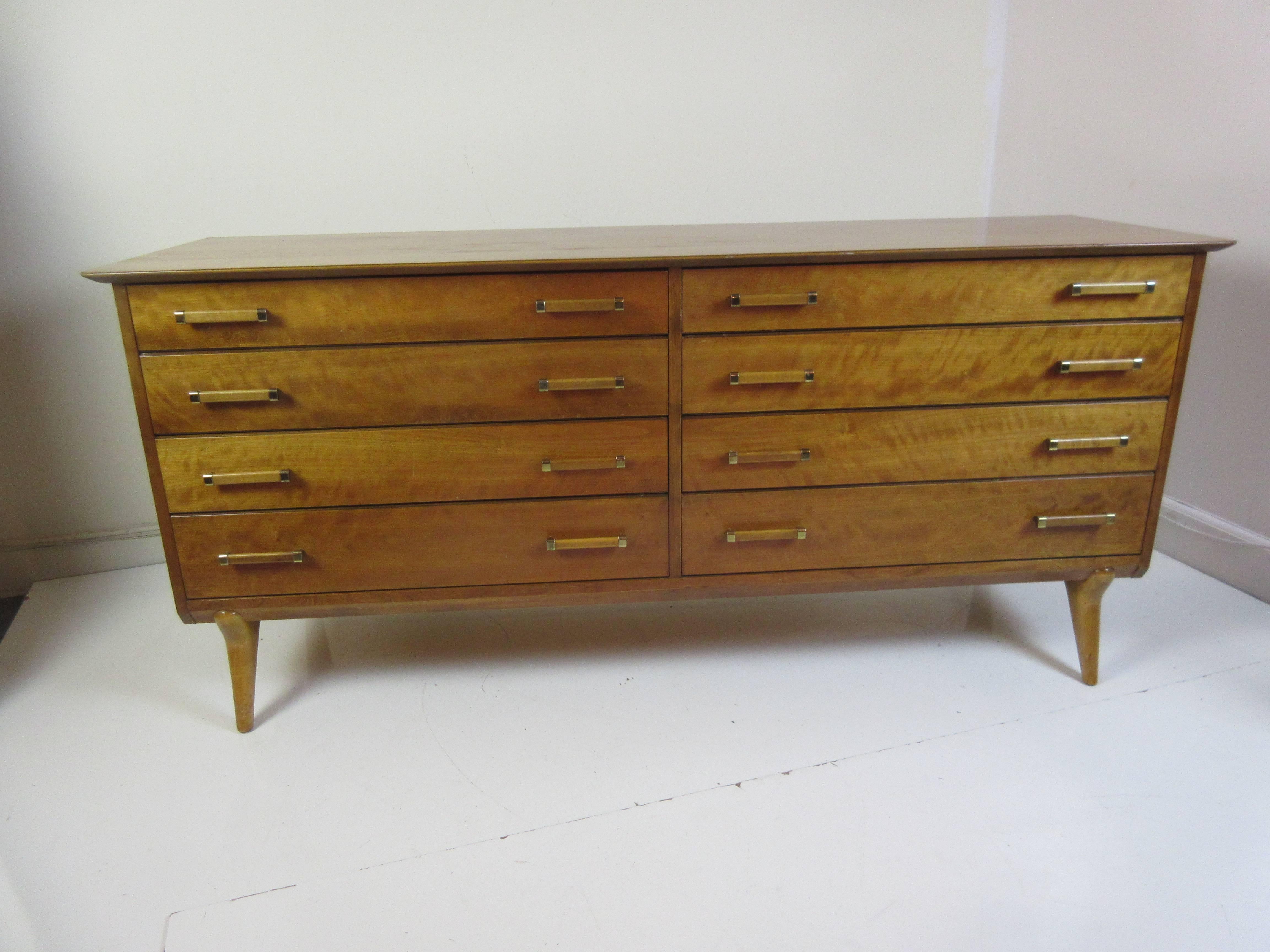 Renzo Rutili Johnson Furniture for John Stuart Dresser in a gleaming honey walnut with brass fittings on the pulls and Rutili's signature Italian style legs in contrasting birch. Top left drawer has branded John Stuart/Johnson Brothers mark and back