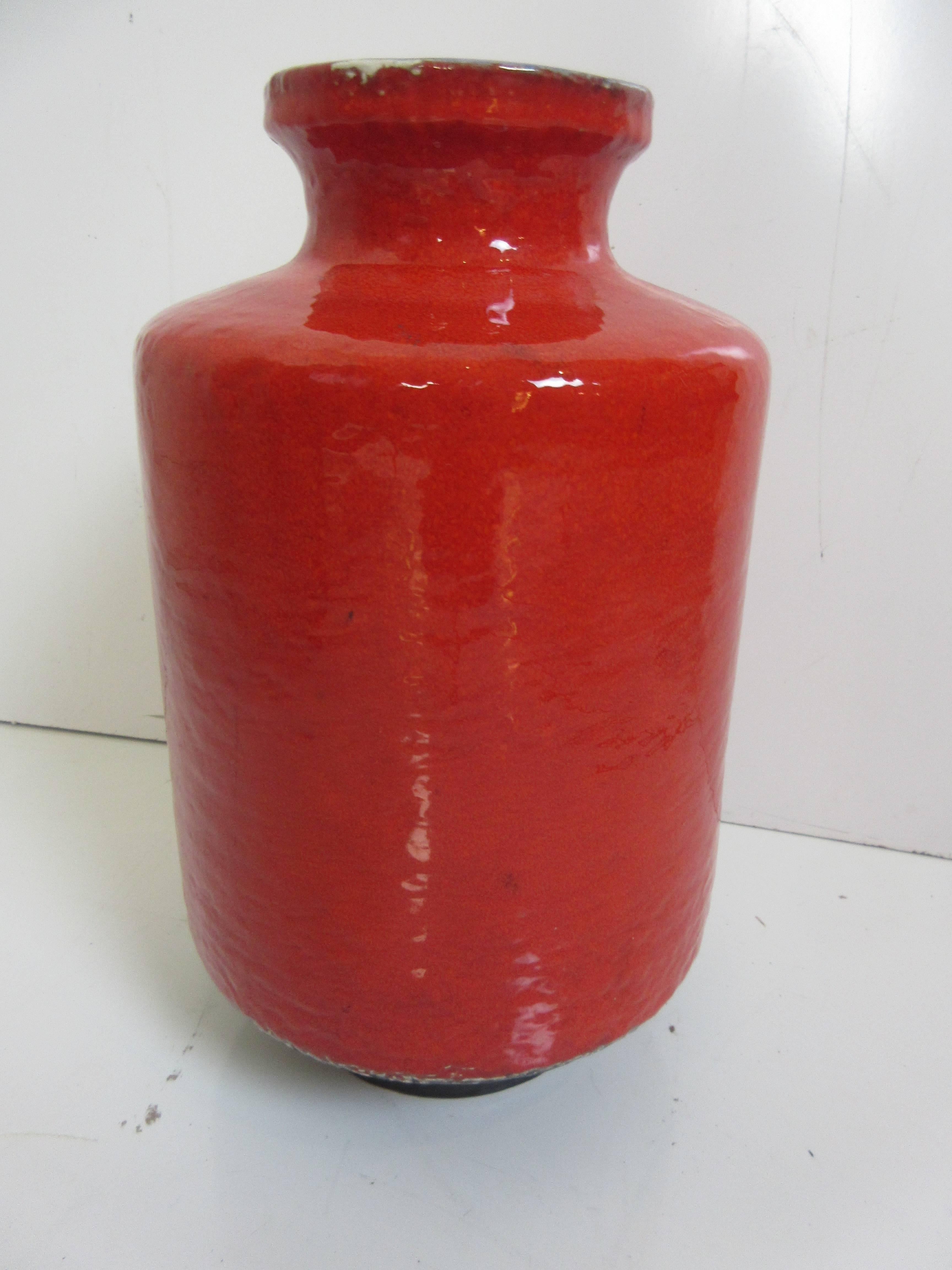 West German vase by Scheurich in brilliant orange red with cobalt blue interior and a charcoal base. Repeating rectangles of charcoal and pale mustard outlined in white accent one half of the main cylinder with the opposite side in the orange red of
