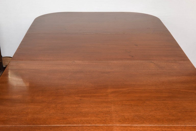 This is a very nice original solid wood dining table in the Regency style, it has three pedestal with Regency style legs and brass cup castors and wheels to the end.
There are two extra leafs the center section and two ends.
The top is in pretty