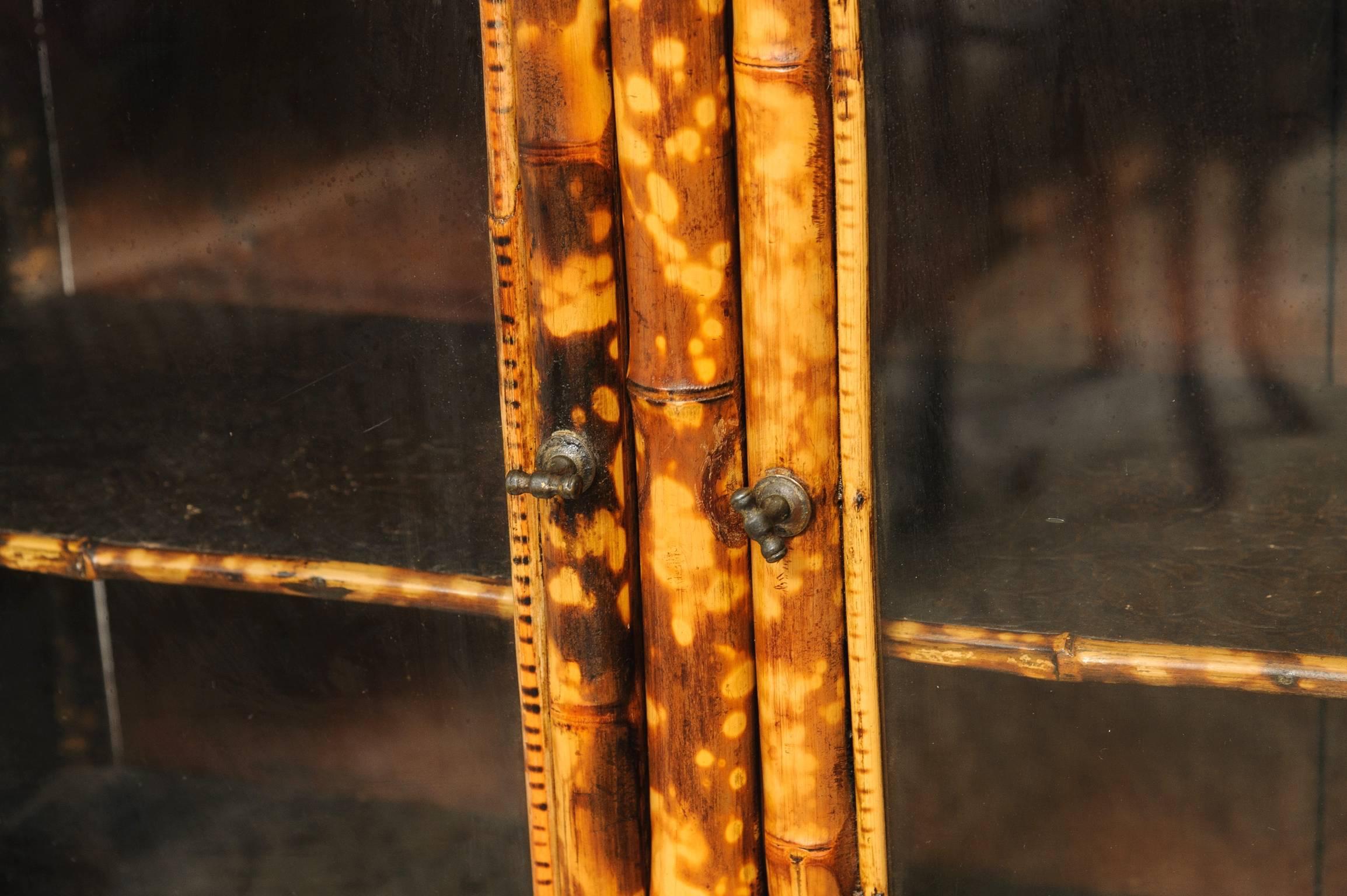 Superb 19th century English bamboo two-door cabinet decorated top shelf with 3/4 gallery. Splay front legs and three shelves. Per inside and out with Japanning and leather paper.