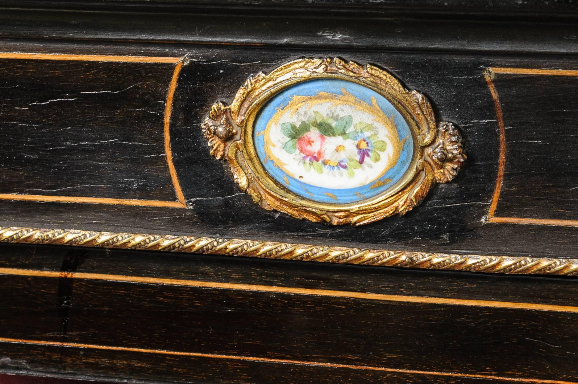 This a a very nice french display cabinet, circa 1890.
The condition is very good, the front has satinwood string inlay as well as brass.
The top center has a Limoges french plaque
Underneath the ebony the cabinet will be solid mahogany.
Inside