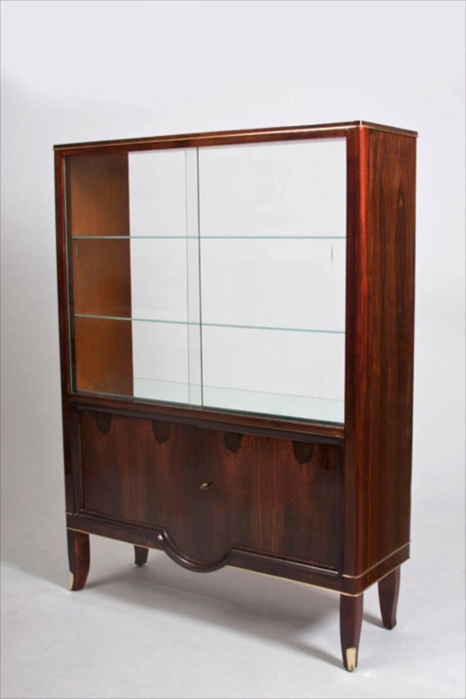 French Art Deco cabinet with vitrine. Rosewood with beveled glass sliding doors and bronze mounts, circa 1938.