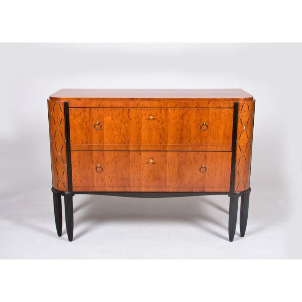 Classic French Art Deco chest of drawers. Burled mahogany with marquetry in exotic hardwoods and mother-of-pearl. Ebonized frame and legs with fluted sculpting, French, 1924. Suite documented.
  