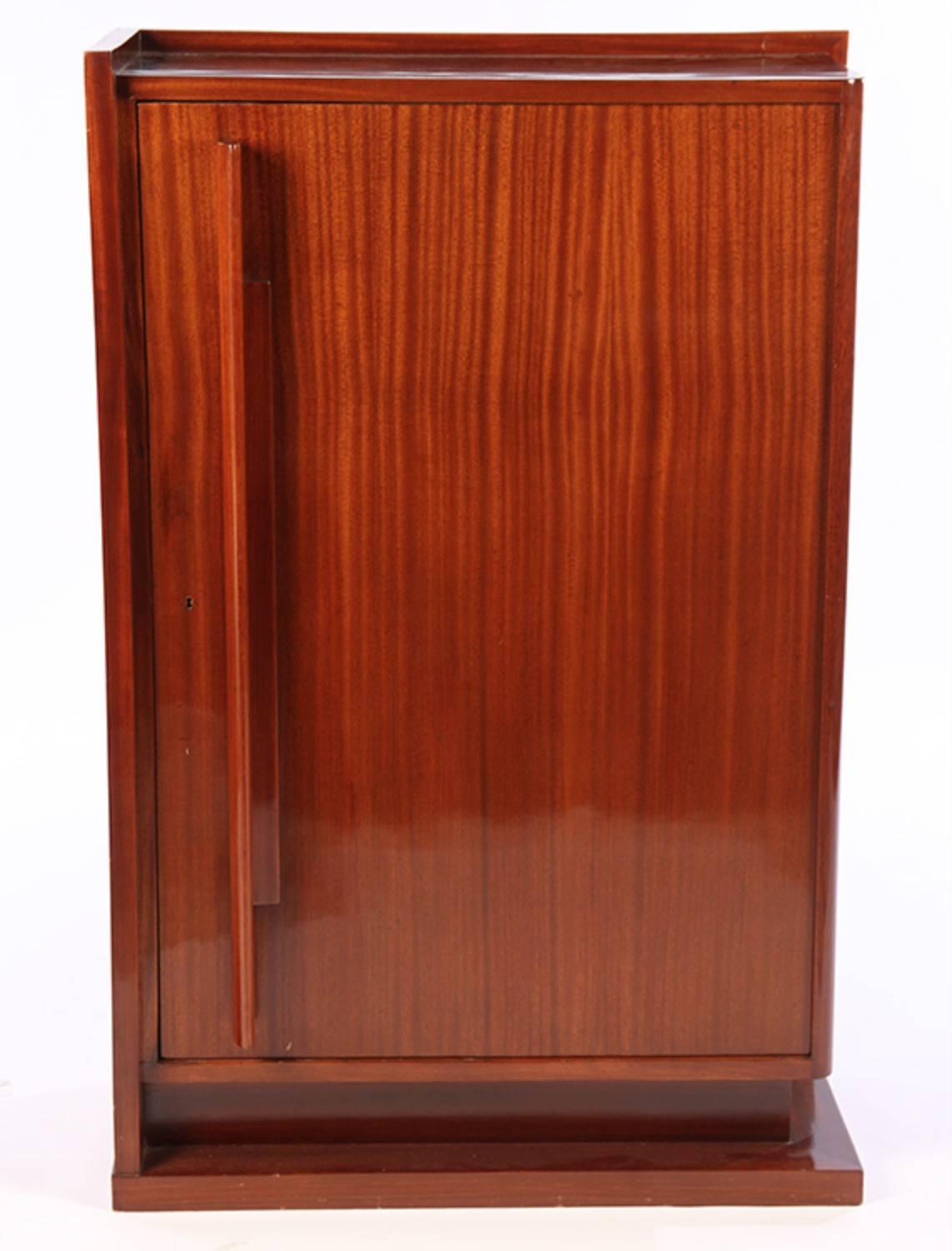 French Art Deco modernist cabinet by Andre Sornay in African mahogany. Detailed with storage shelving interior. Measures: 32