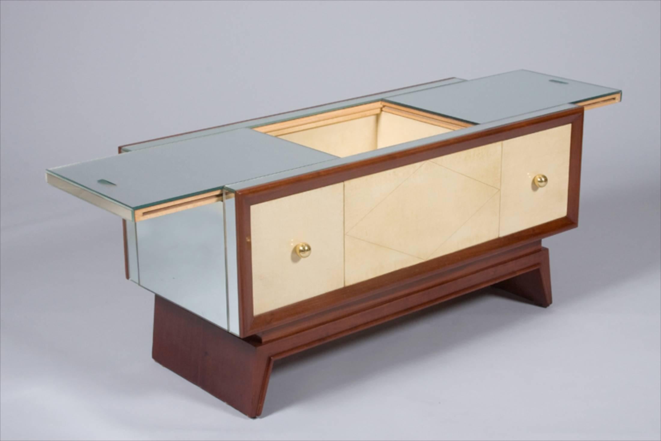 French Art Deco coffee table by Maurice Champion, circa 1935, in mirror and mahogany with original parchment facings and bronze fittings. Slides open from center to reveal fully parchment-lined storage.