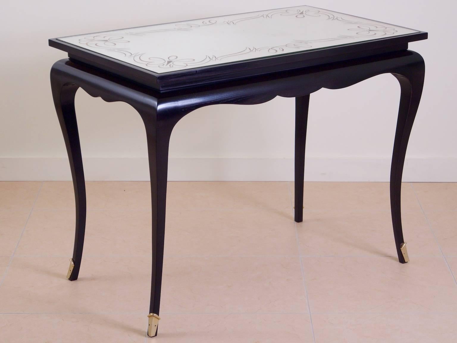 French Art Deco salon table, center table or writing table by André Arbus, circa 1937. Ebonized sycamore with nickled bronze mounts and verre églomisé top.