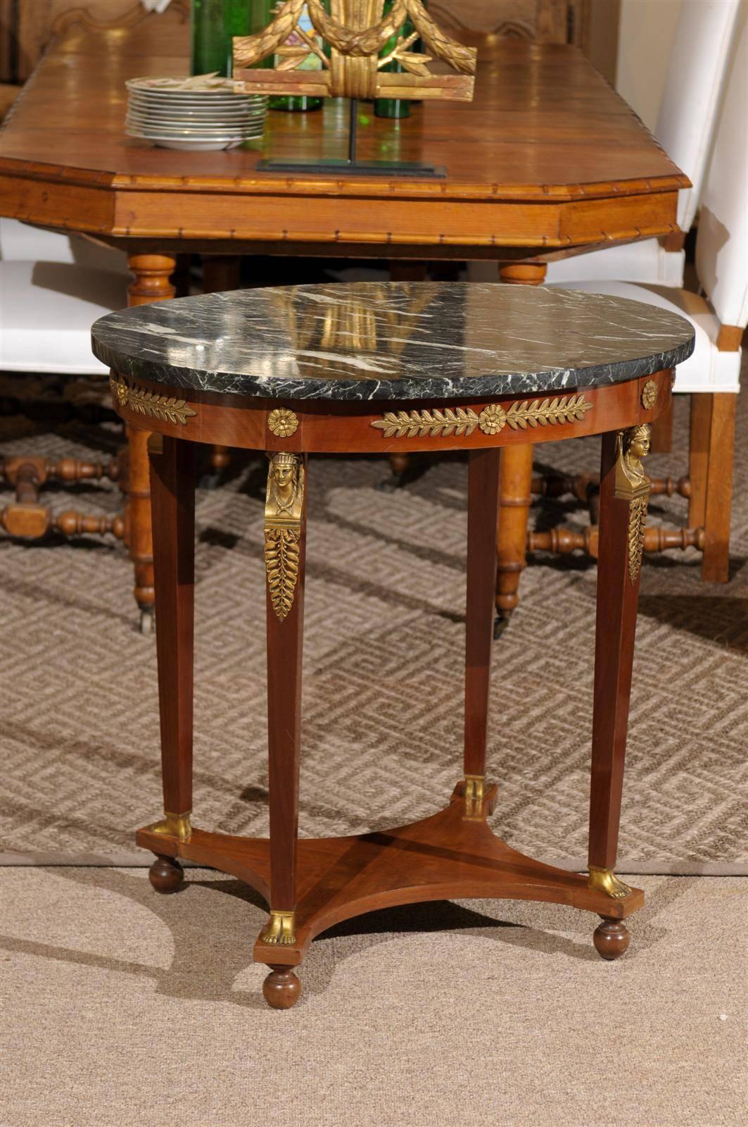 Empire Style Mahogany Oval Gueridon with Marble Top, circa 1900
This little table contributes a lot of drama for its size. It is a very pleasing oval shape and the marble has a lot of pattern. The bronze kings on the legs and the bronze