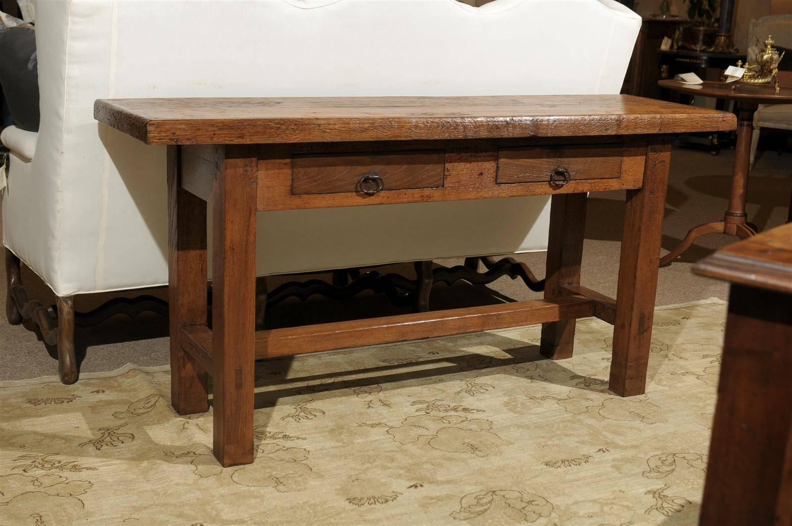 This table would be perfect for serving in a dining room, behind a sofa, or in a hallway. It is made of solid oak with a stretcher style base. Two smaller drawers make it complete. It is newly constructed from a 19th century French dining table, so